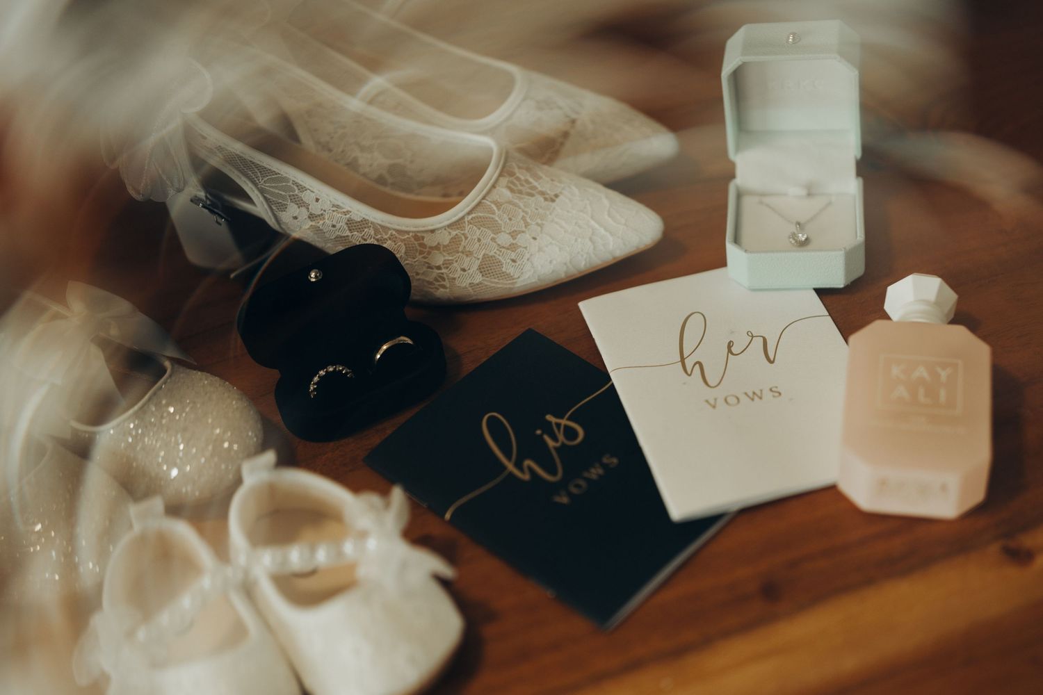Luxury beauty products and perfume bottles arranged on wooden surface with soft lighting and elegant packaging.