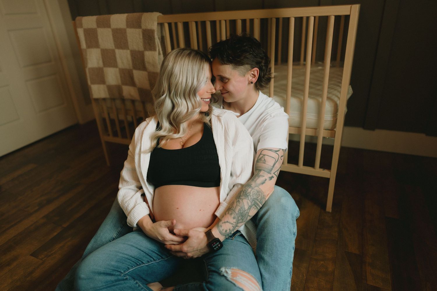 Intimate maternity photography session showing tender moments between expectant parents in a cozy home setting.
