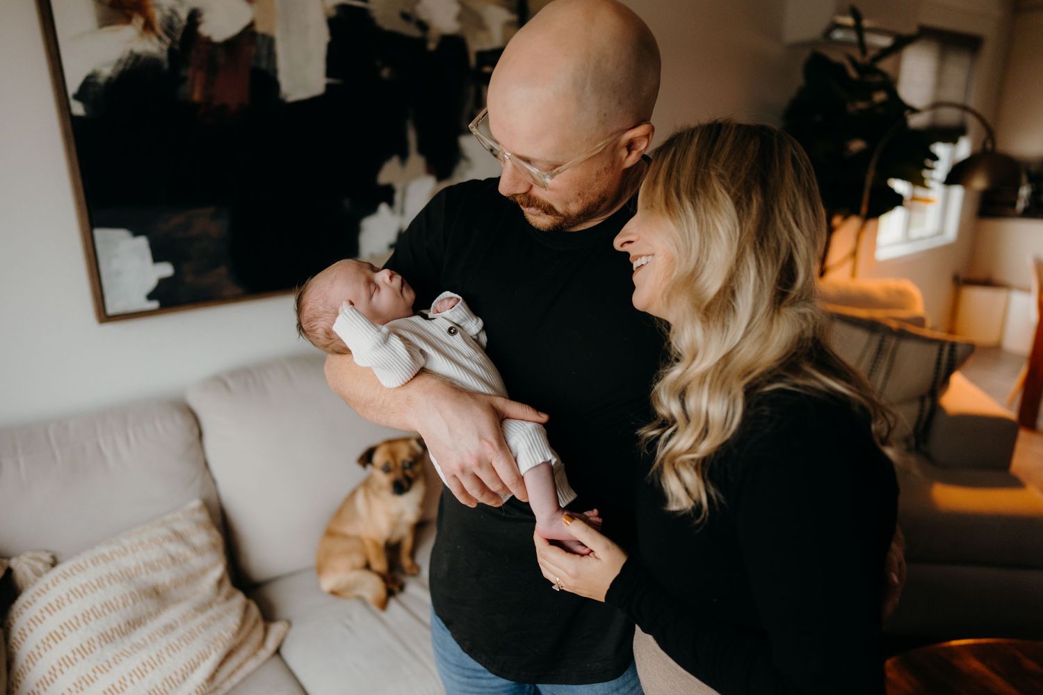 A tender family moment captured during an intimate lifestyle photo session in warm indoor lighting.