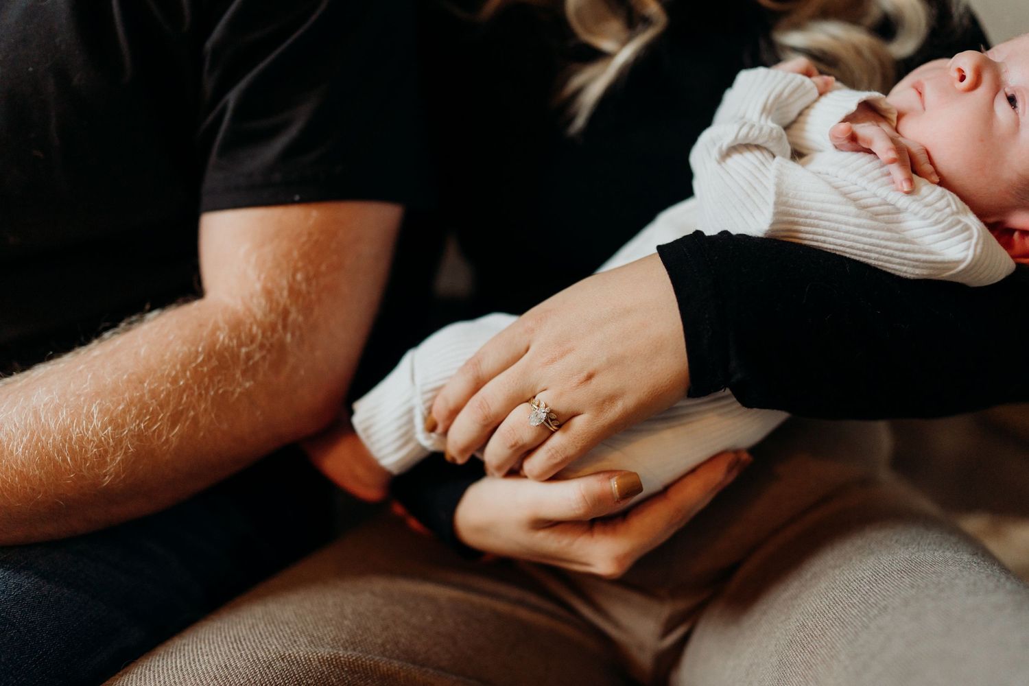 Detail shot of hands and clothing during an intimate indoor photo session.
