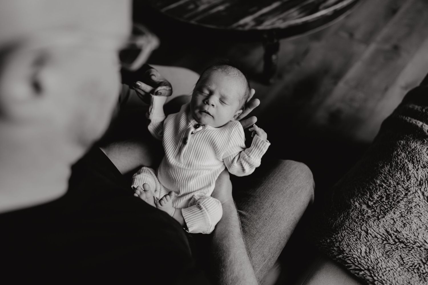 Intimate family photography capturing quiet moments with newborn at home.