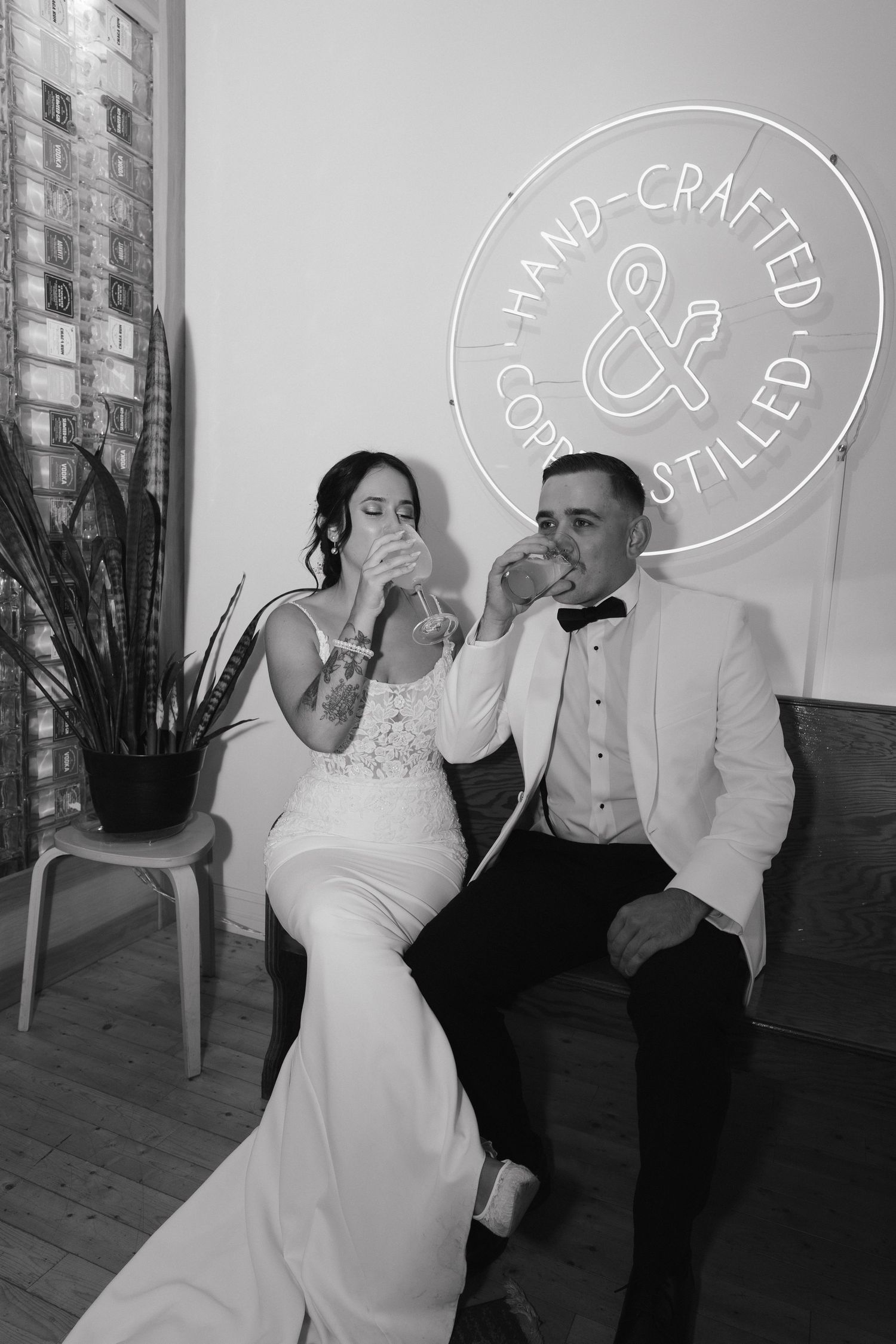 Black and white photo series of a couple in wedding attire sharing playful moments in a modern indoor setting.