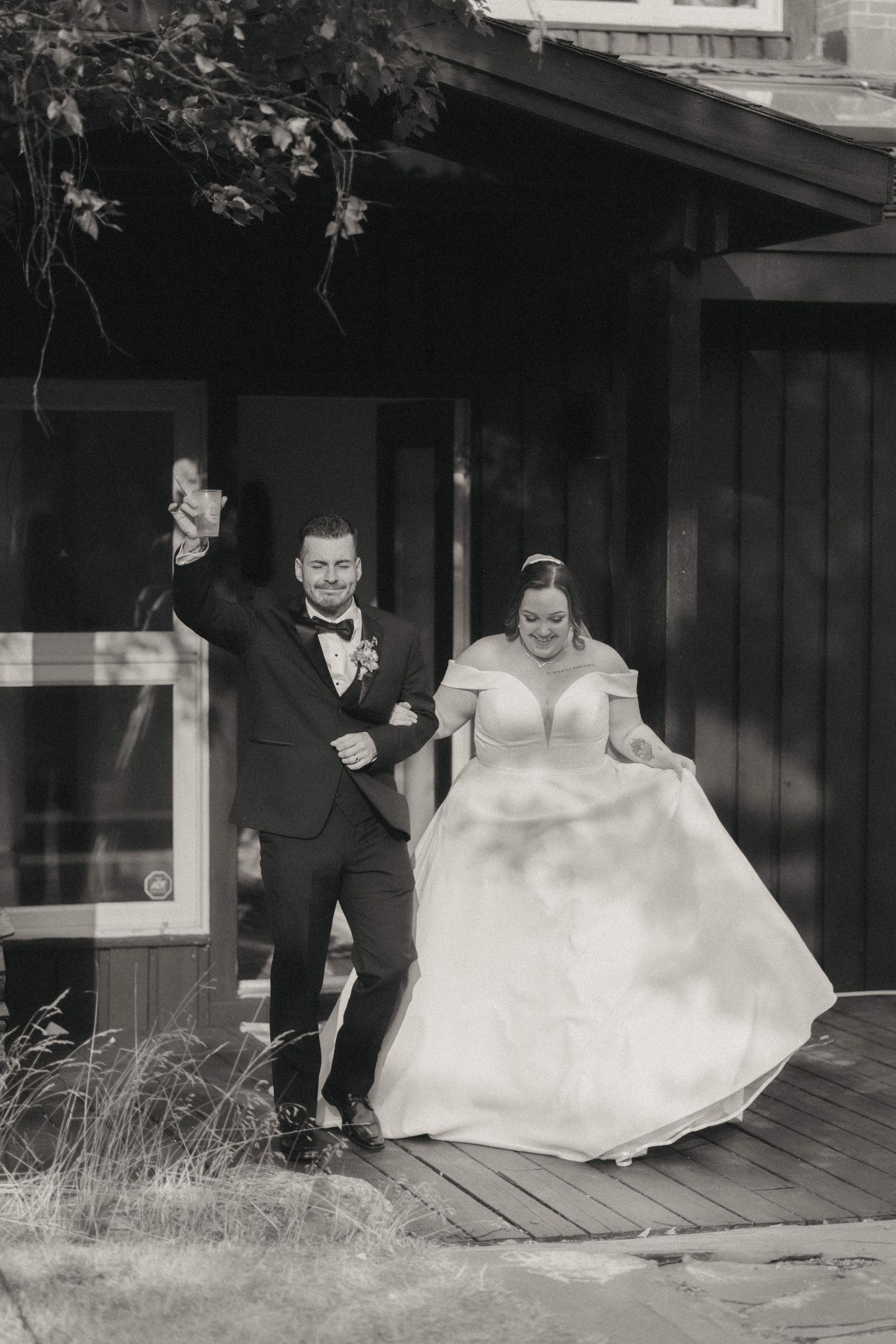 Black and white photograph of a celebratory moment on a wooden deck.