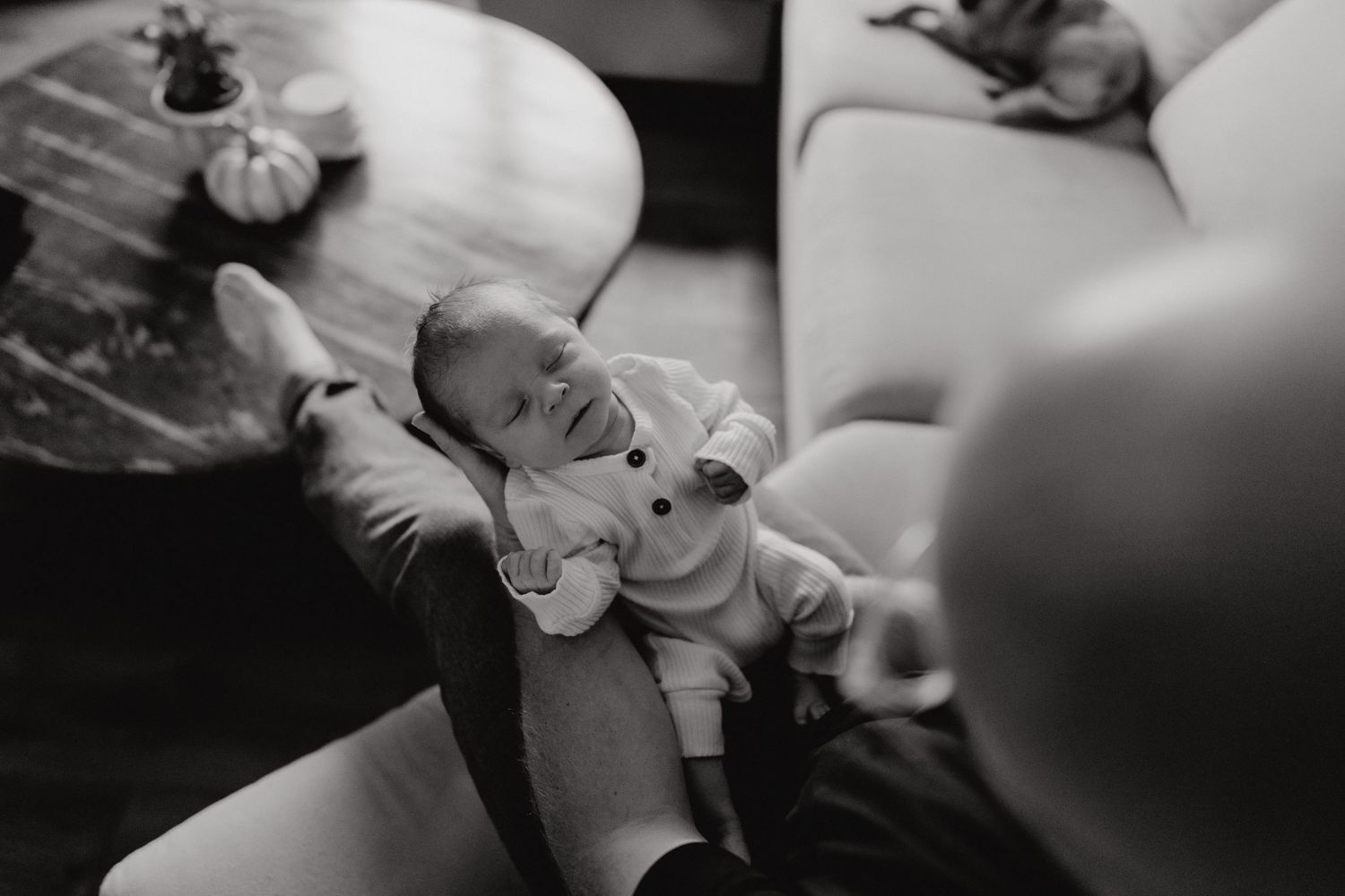 Gentle black and white portrait of a sleeping infant being held.