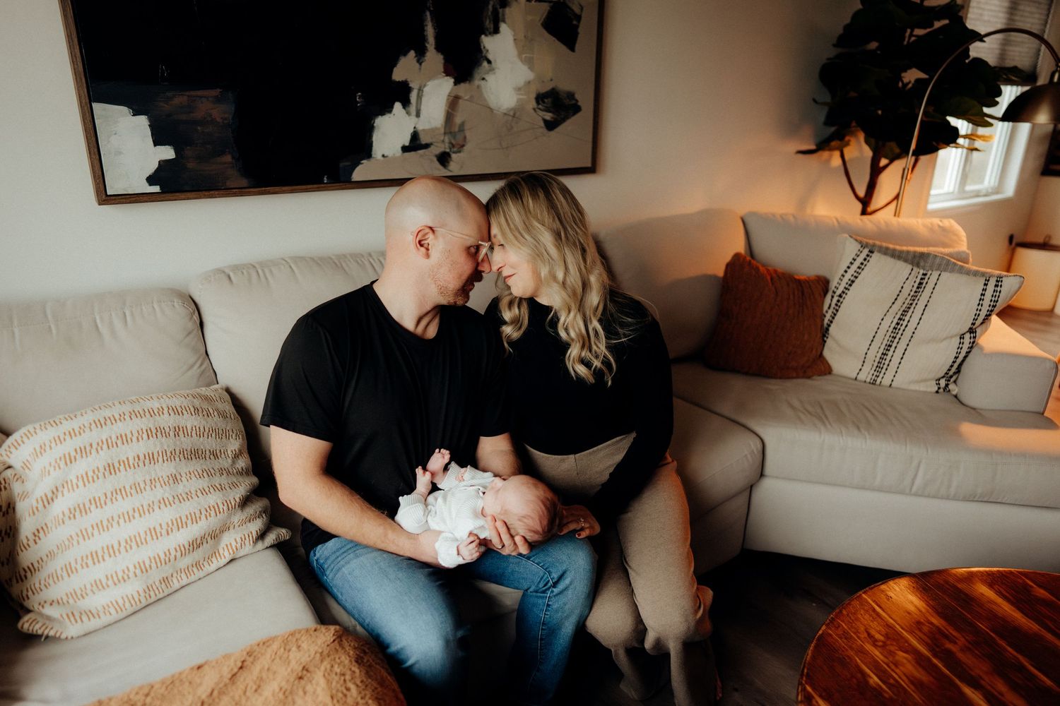 Family lifestyle session showing intimate moments on a couch with soft window light.