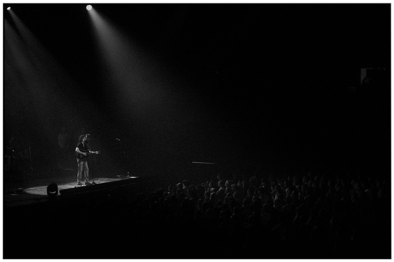 A series of black and white concert performance photos showing silhouettes of musicians on stage with dramatic lighting.