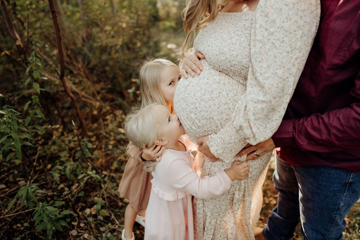 Autumn maternity session featuring couple in burgundy and cream lace outfits.