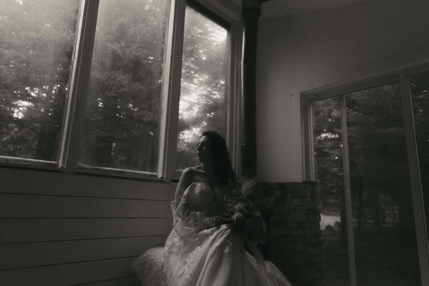 A monochrome image showing sunlight streaming through windows in an interior space.