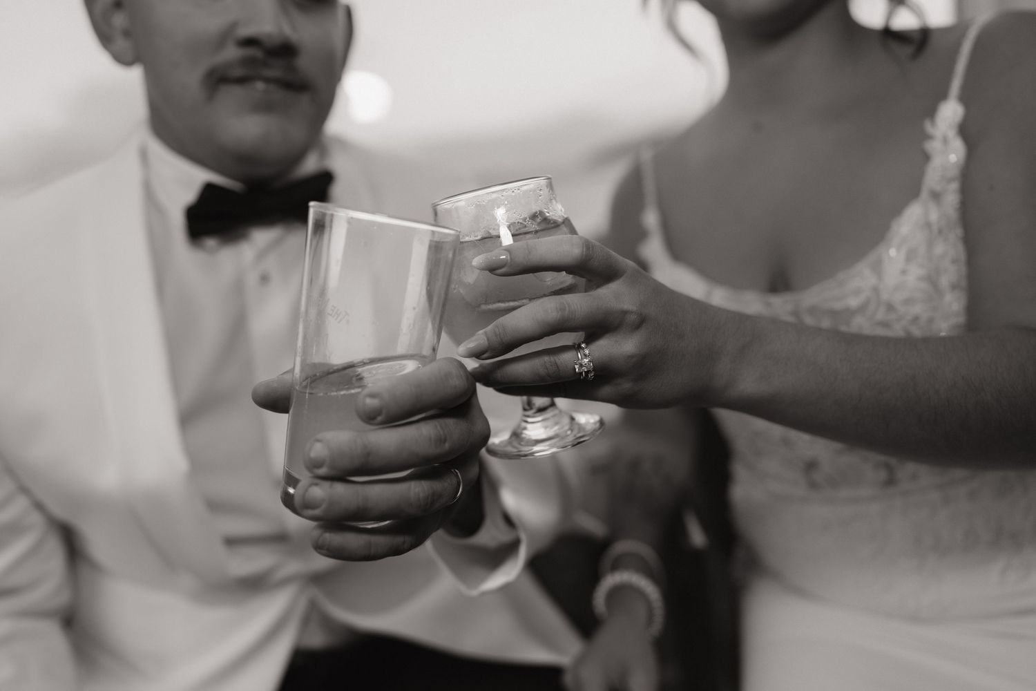 Black and white collage of hands holding beverages and toasting at a celebration.
