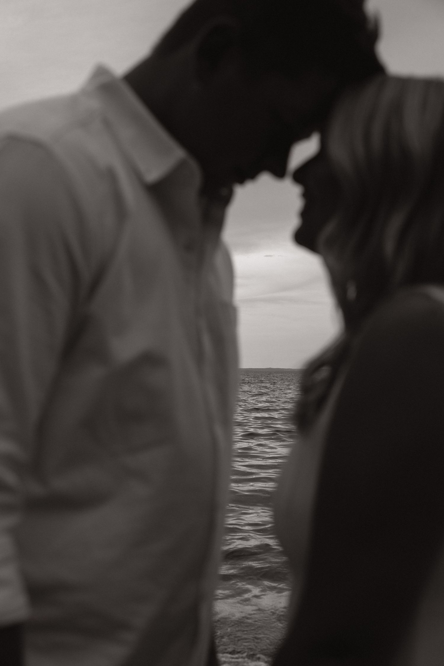 A series of black and white photographs showing silhouettes of people against a seascape background.