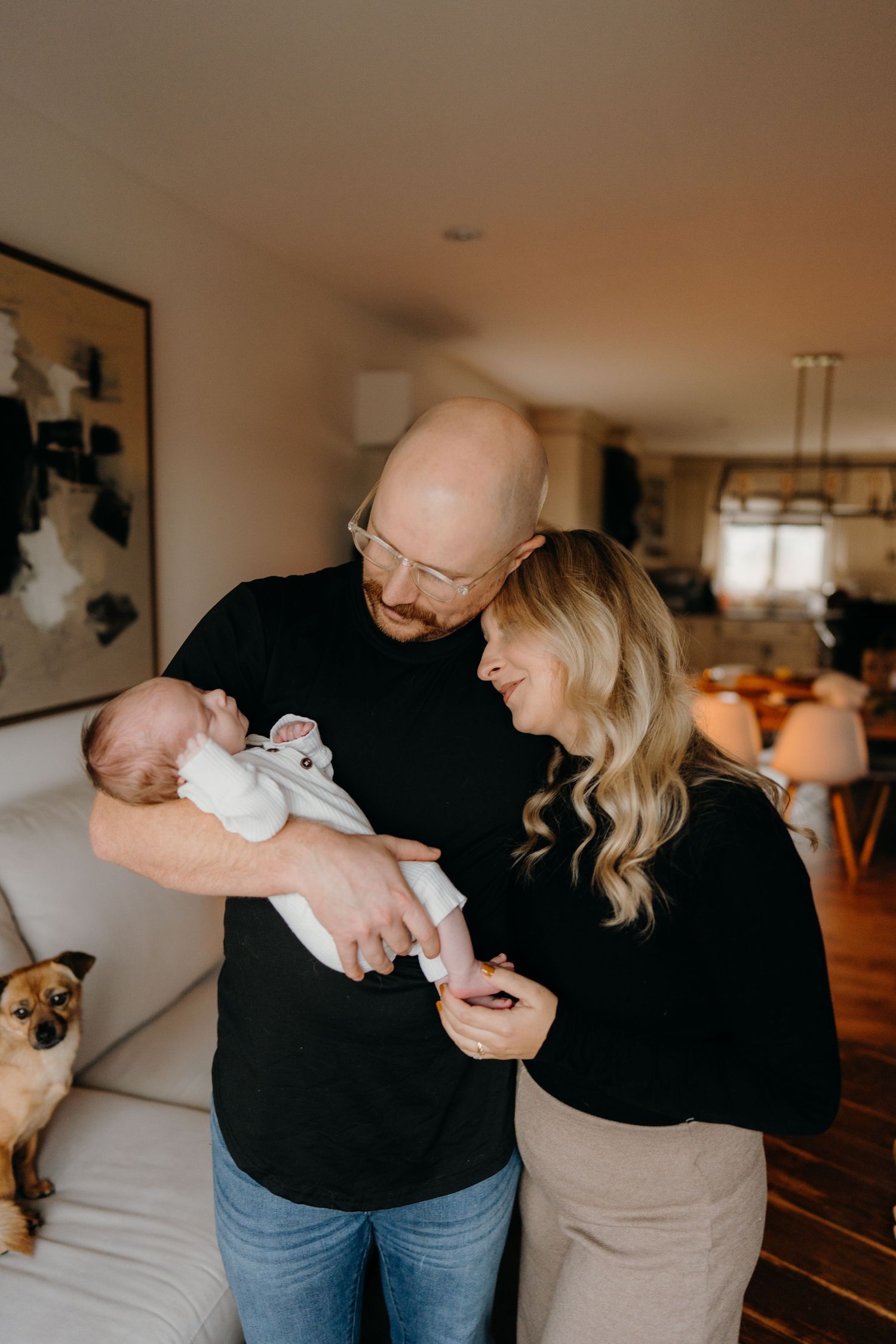 Parents share intimate moments with their newborn baby in their cozy home.