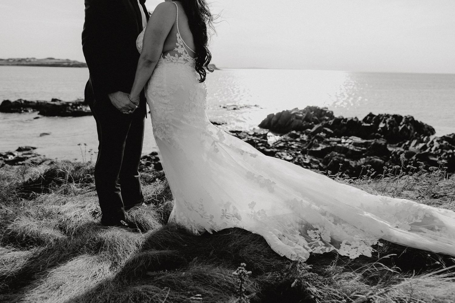 Black and white wedding photo series showing moments from a coastal celebration against rocky shores.