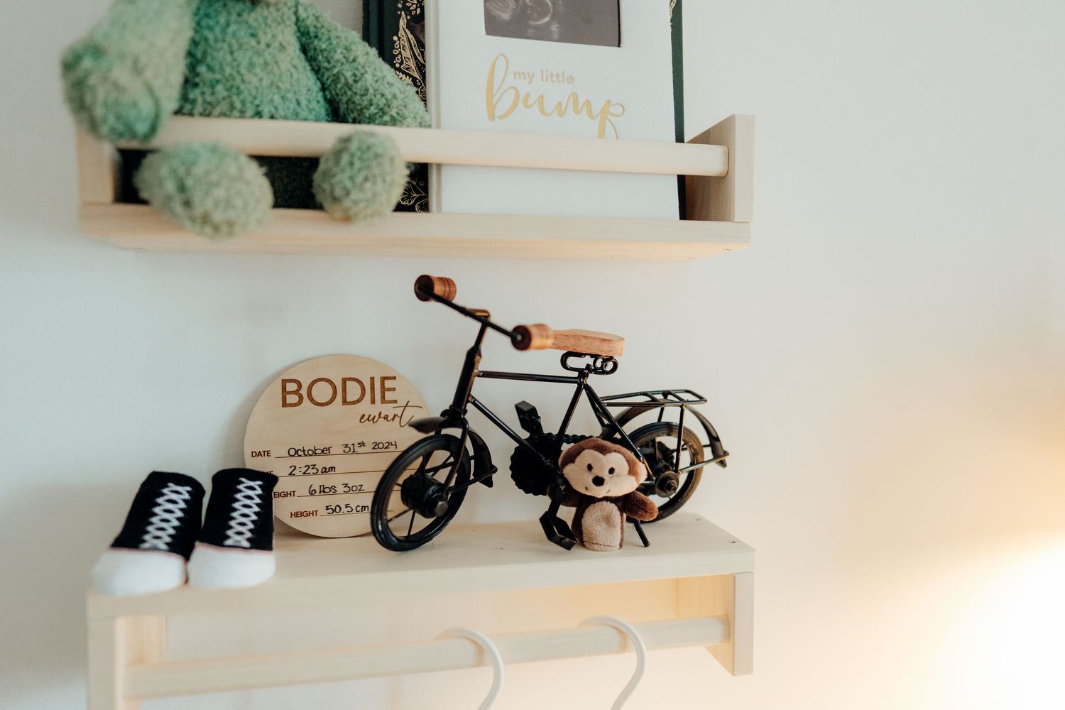 Nursery shelf with mint green plush toys and decorative items.