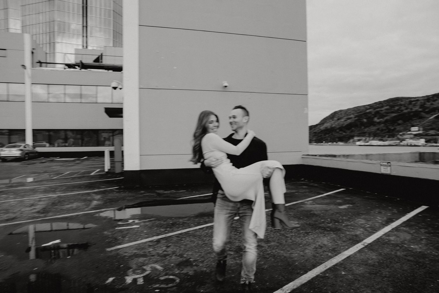 A couple shares a romantic moment during a rooftop photoshoot.
