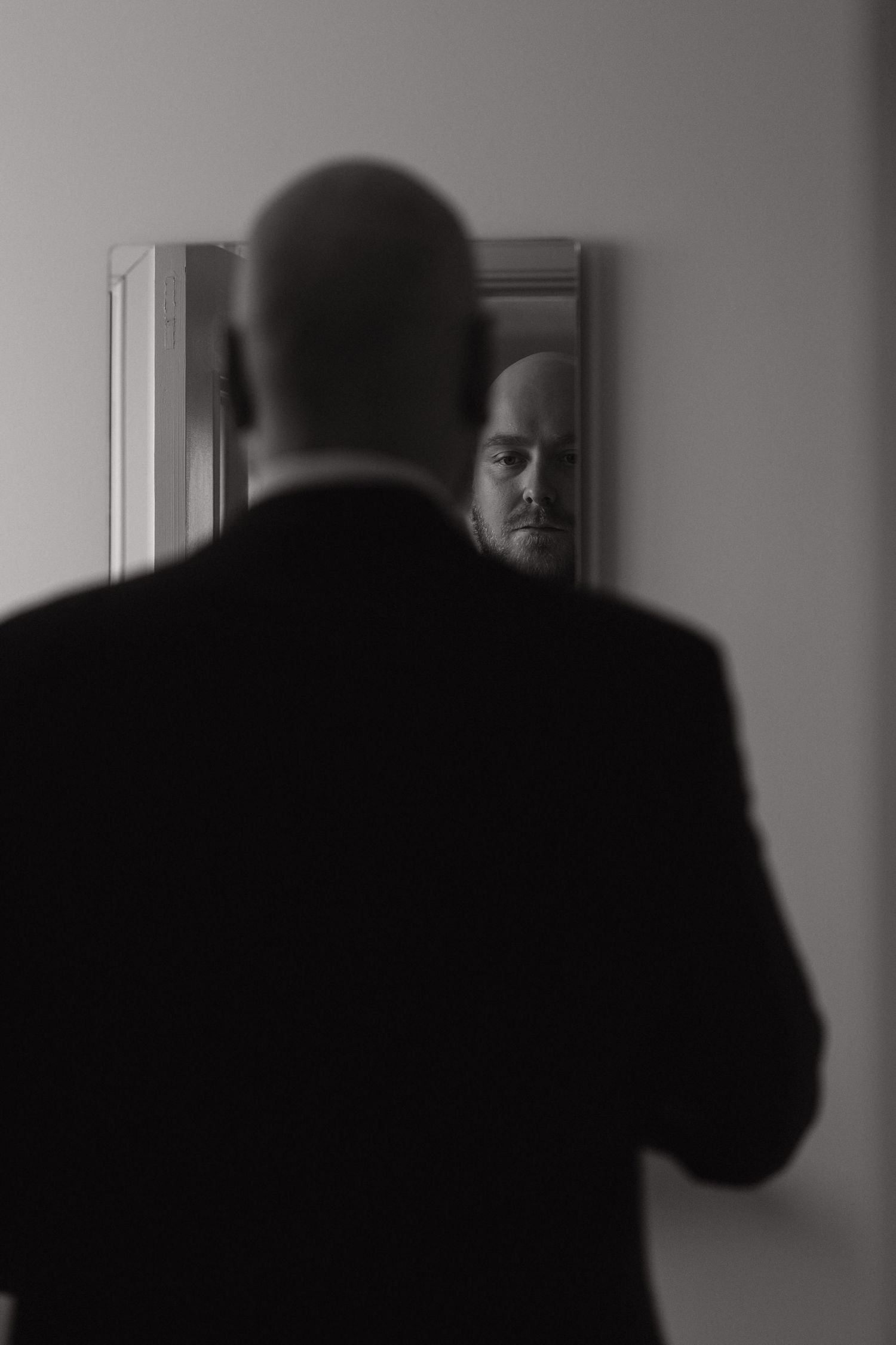 A black and white photo sequence shows a silhouetted figure walking past a window in a darkened hallway.
