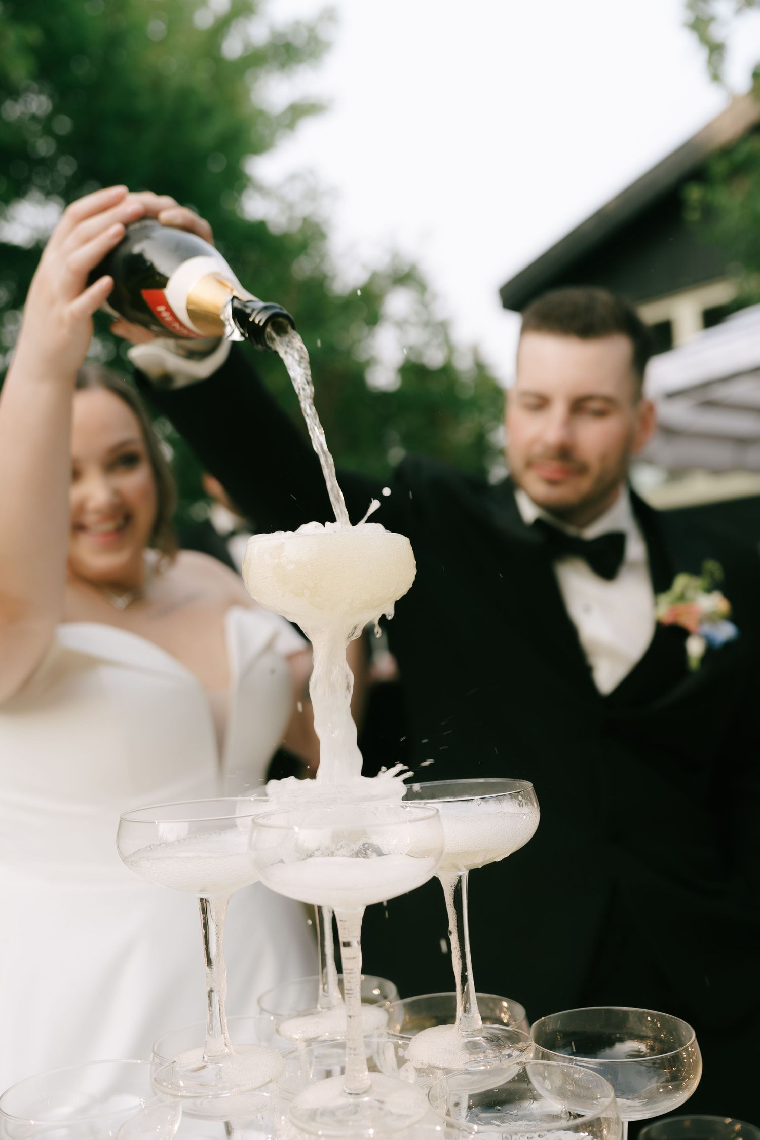Bubbly champagne flows through multiple tiers of crystal glasses creating a beautiful fountain effect.