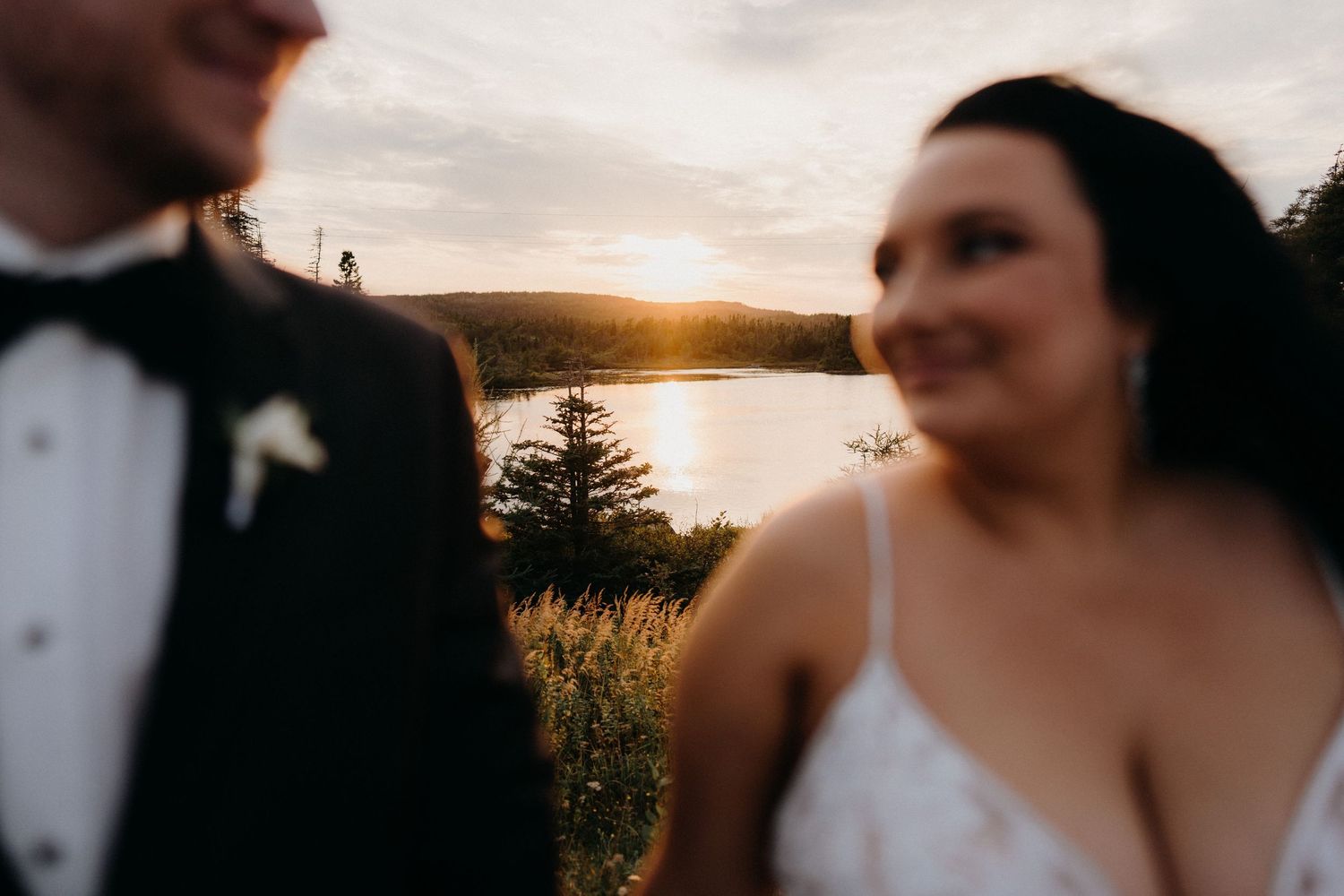 Romantic sunset silhouette of newlyweds against an ocean backdrop.