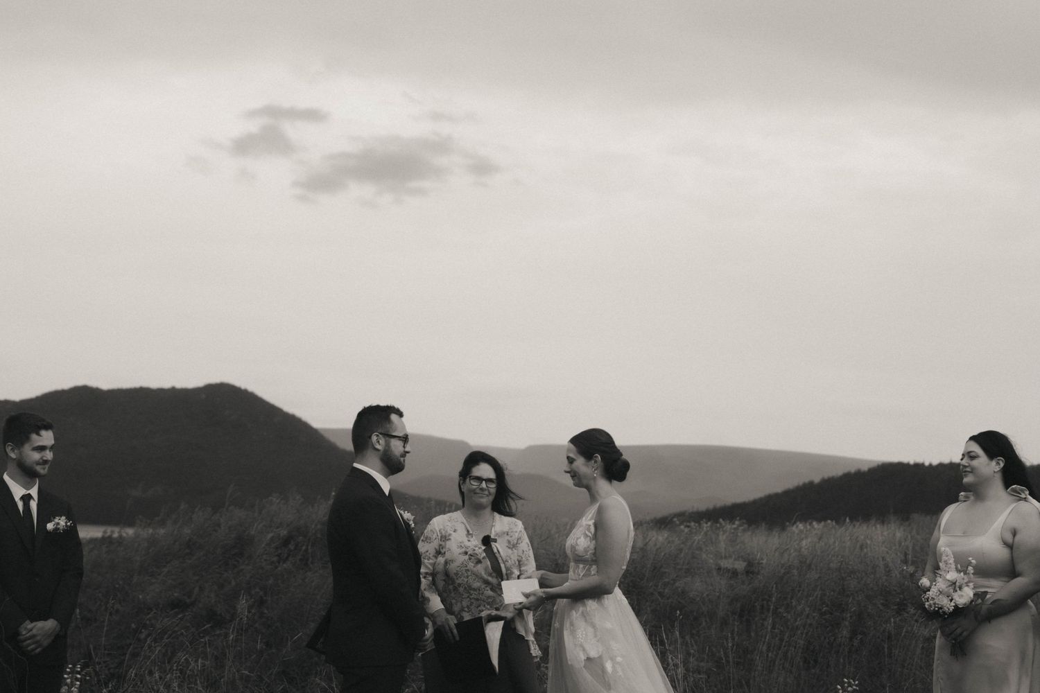 Several people gather in an outdoor setting for what appears to be an informal ceremony or gathering in a rural area.