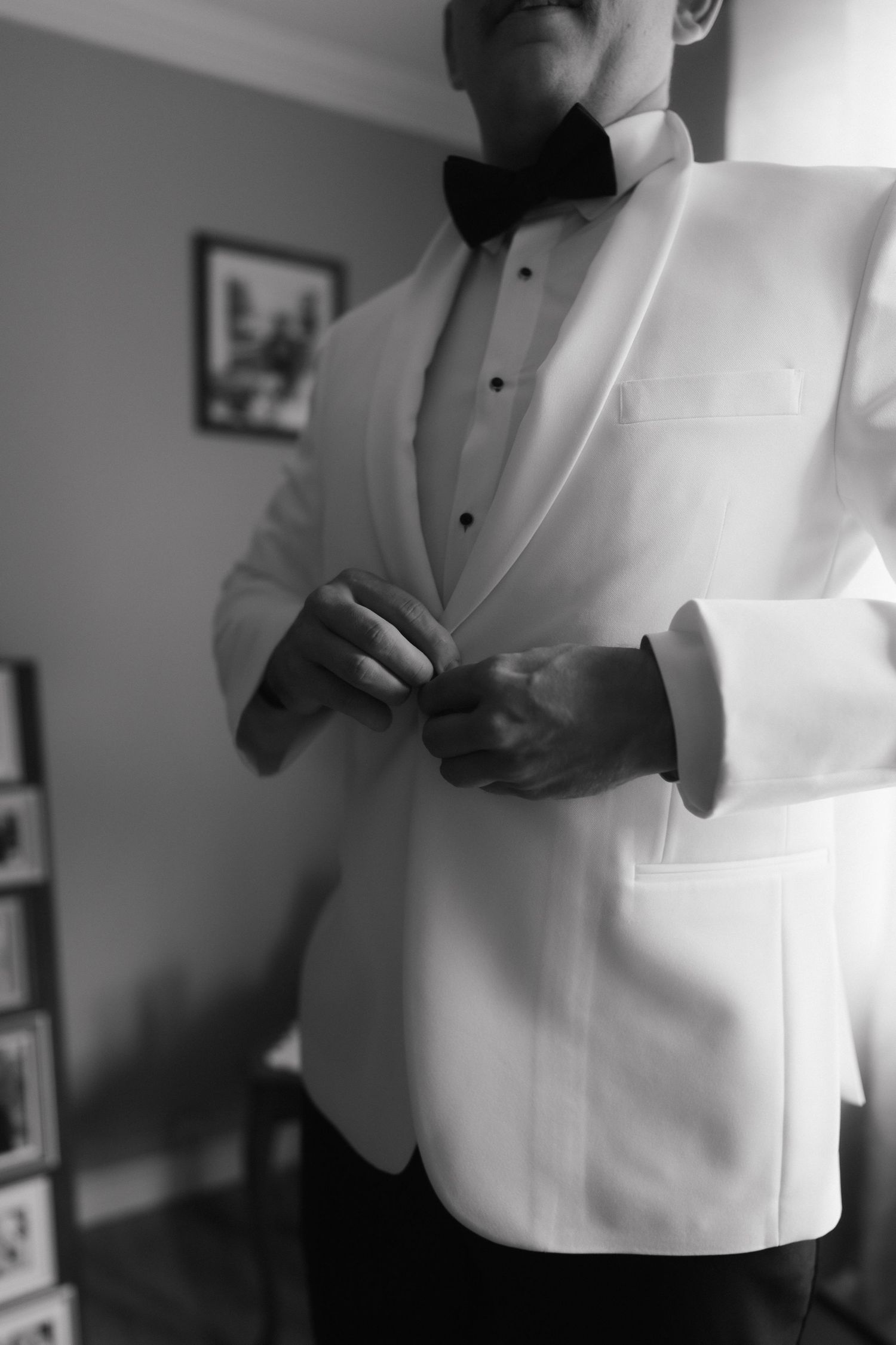A series of black and white photos showing close-up details of someone adjusting a formal white tuxedo jacket.