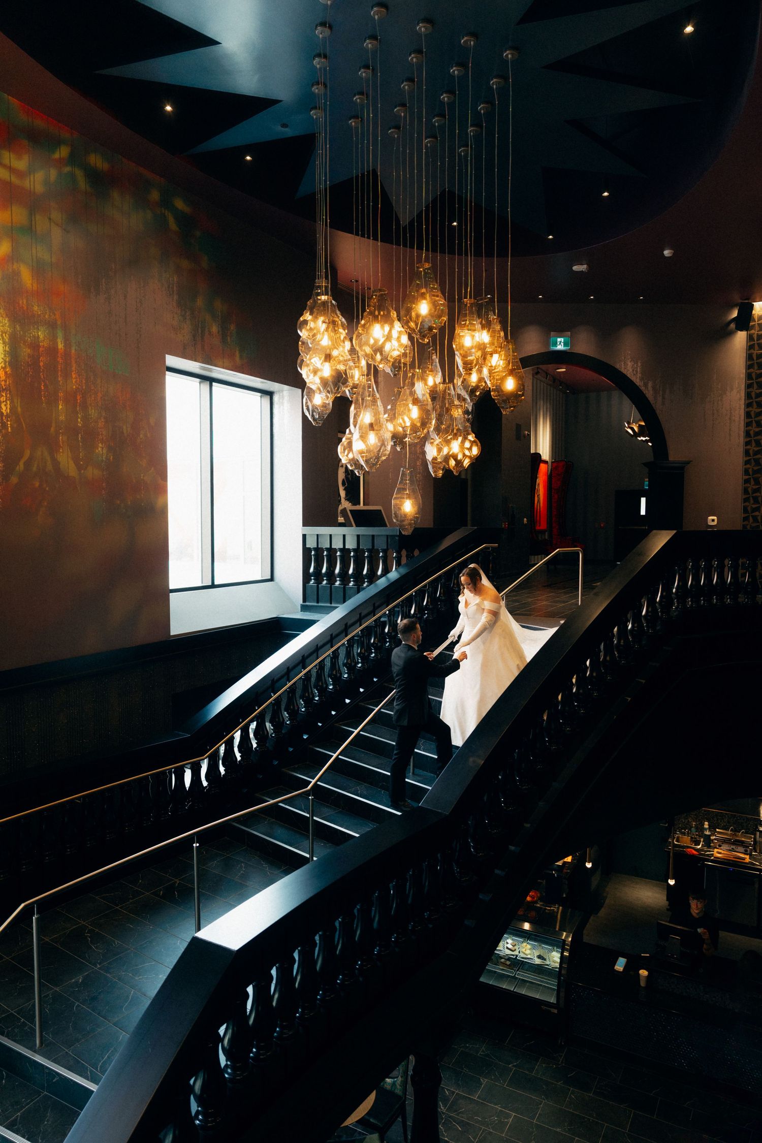Moody wedding photos captured in venue with hanging crystal lights and dark ambiance.