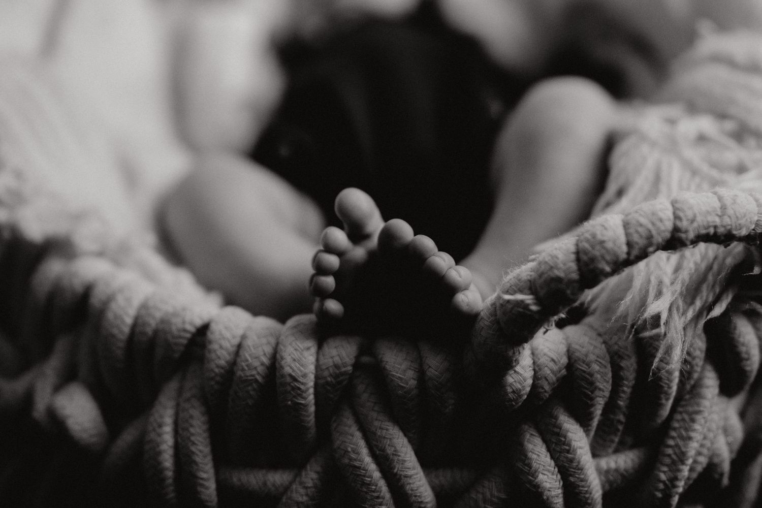 Close-up detail shots of hands touching in dramatic black and white photography.