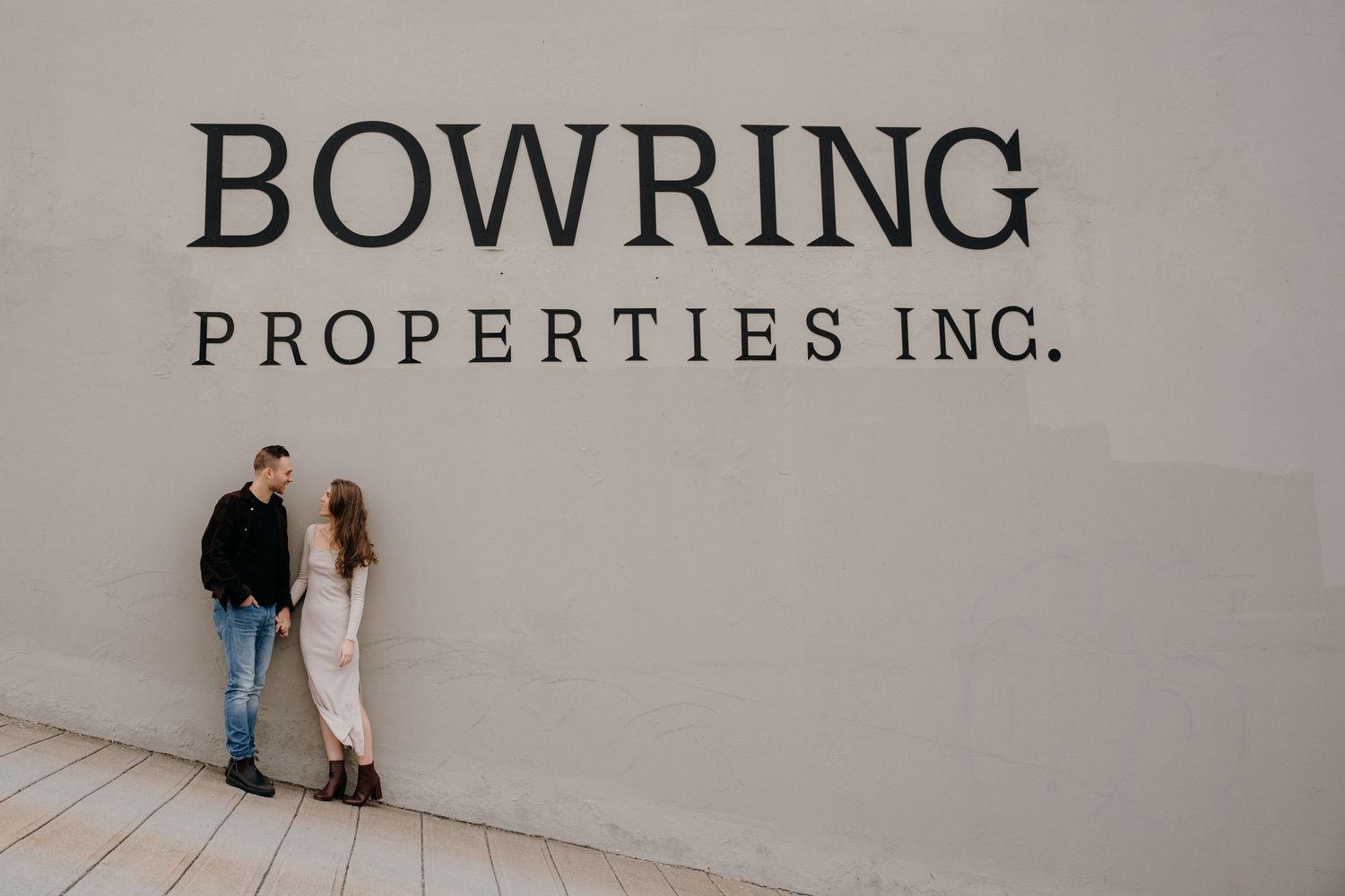 Bowring Properties Inc signage displayed on a white wall with people in the distance.
