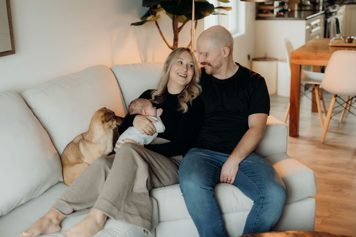 A couple relaxes together on a couch in an intimate lifestyle photography session.
