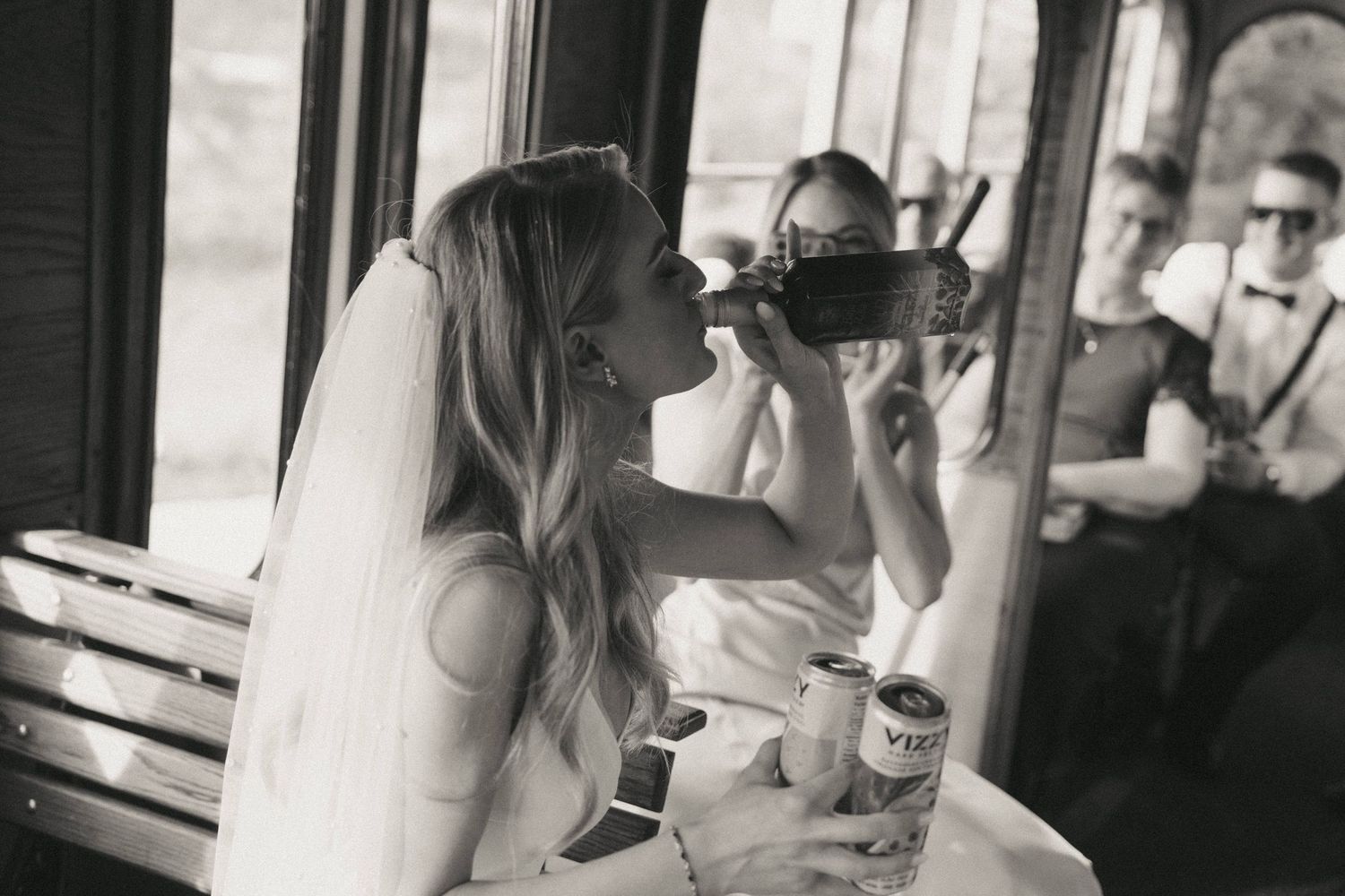Candid black and white moments captured through window of vintage vehicle.