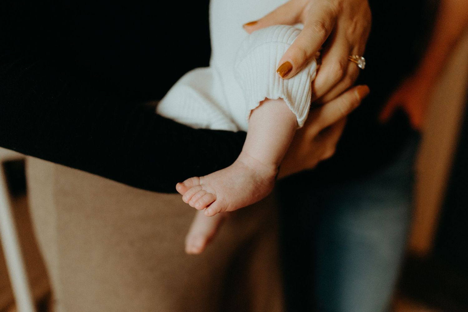 Close view of caring hands gently touching a newborn baby.