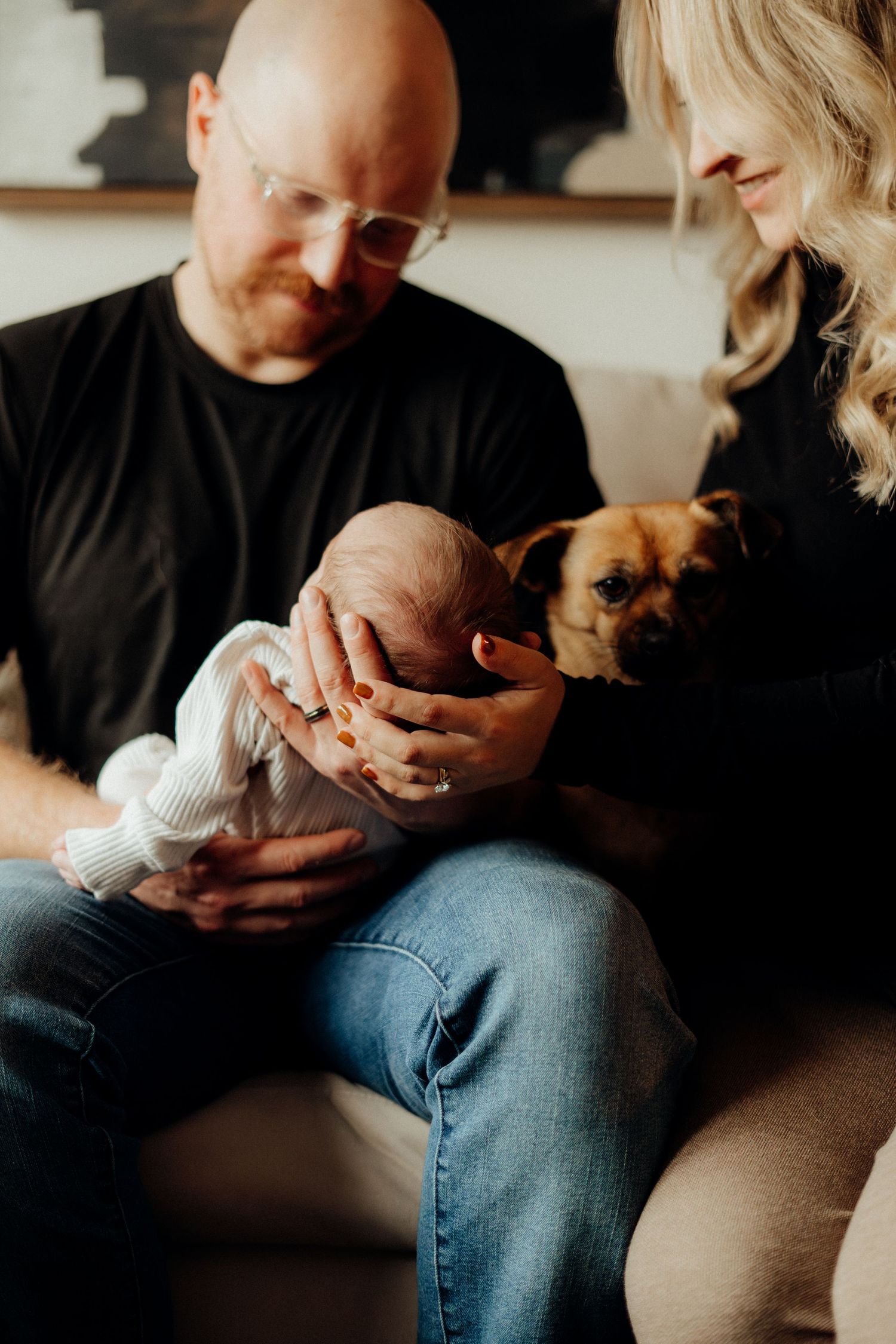 A close-up view of a parent holding and gazing at a newborn in a cozy indoor setting.