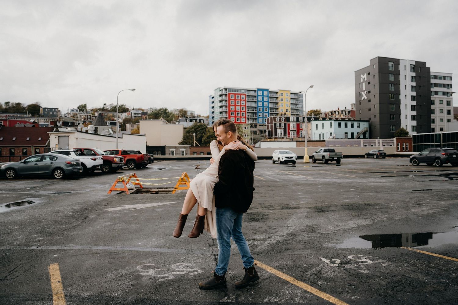 A romantic dance scene unfolds on a concrete rooftop with apartment buildings in the distance.