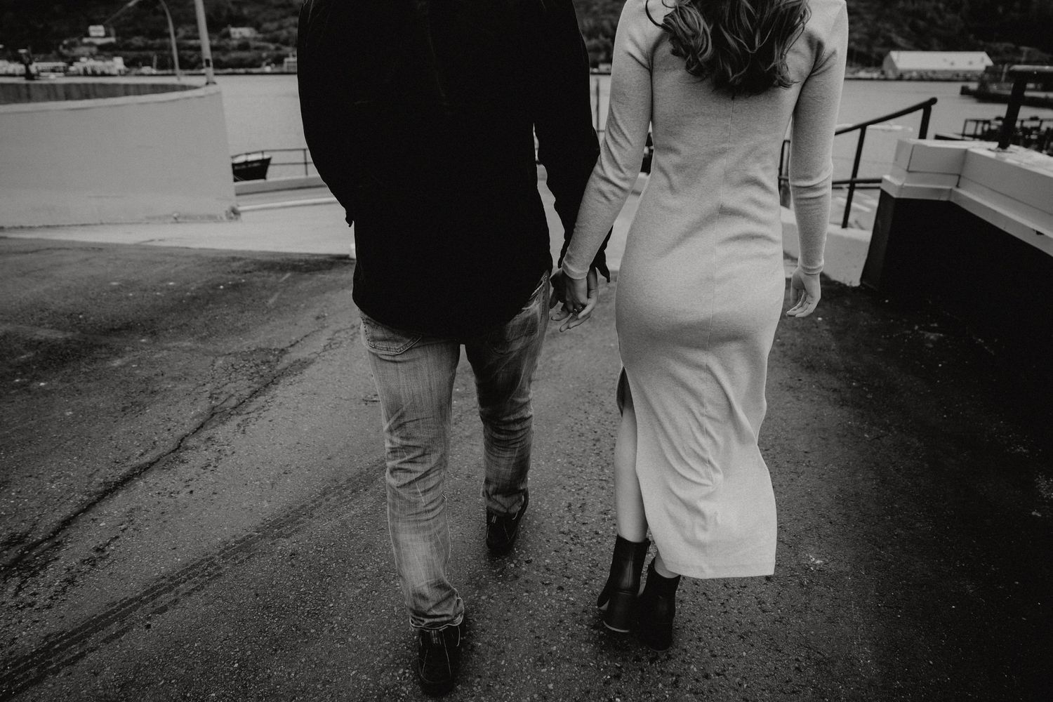 A monochrome image of two people walking together, captured from behind.