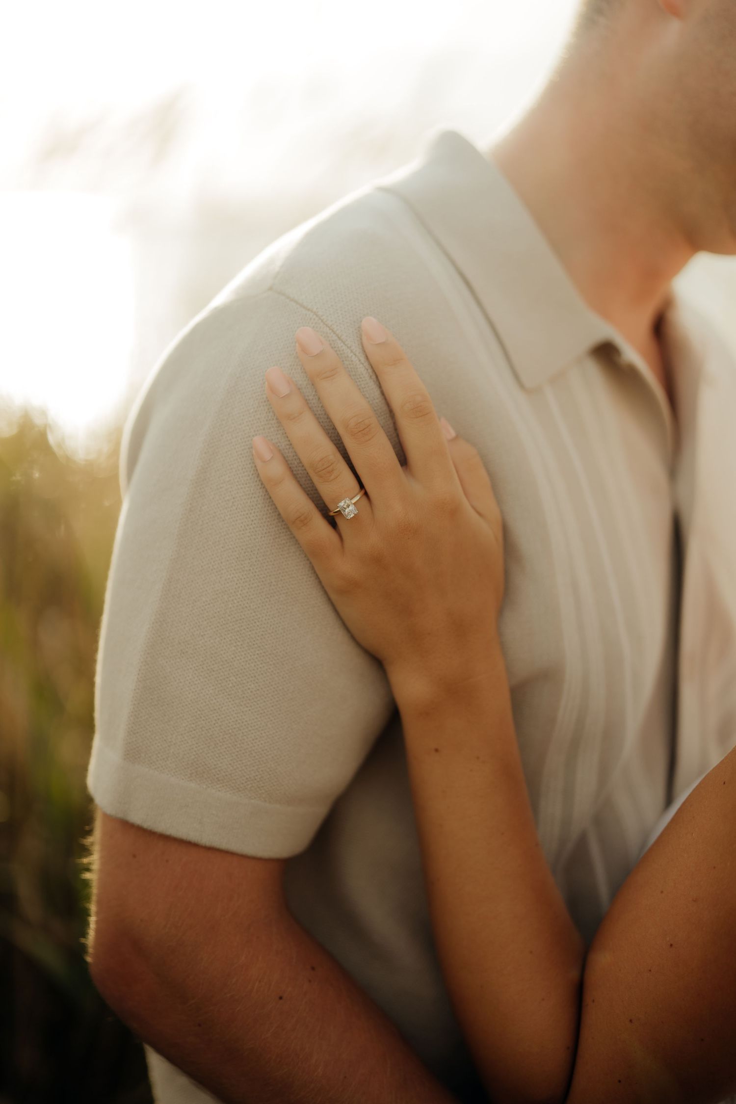 A close-up series of engagement photos showing hands with a diamond ring against a white shirt.