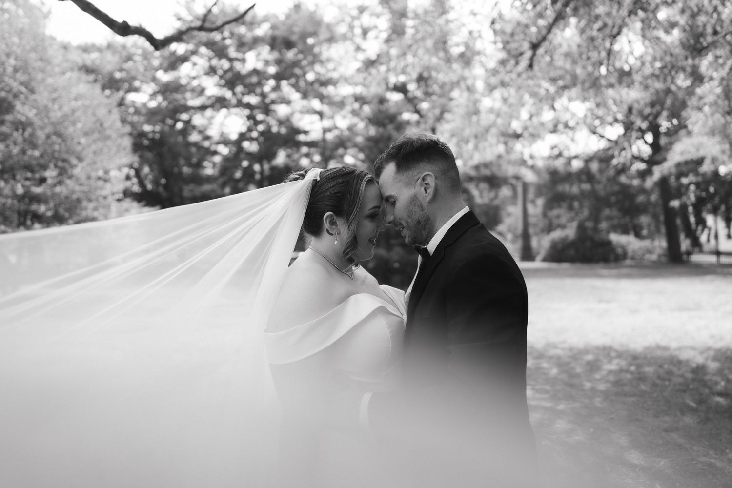Intimate black and white wedding portrait series of a couple sharing romantic moments outdoors.