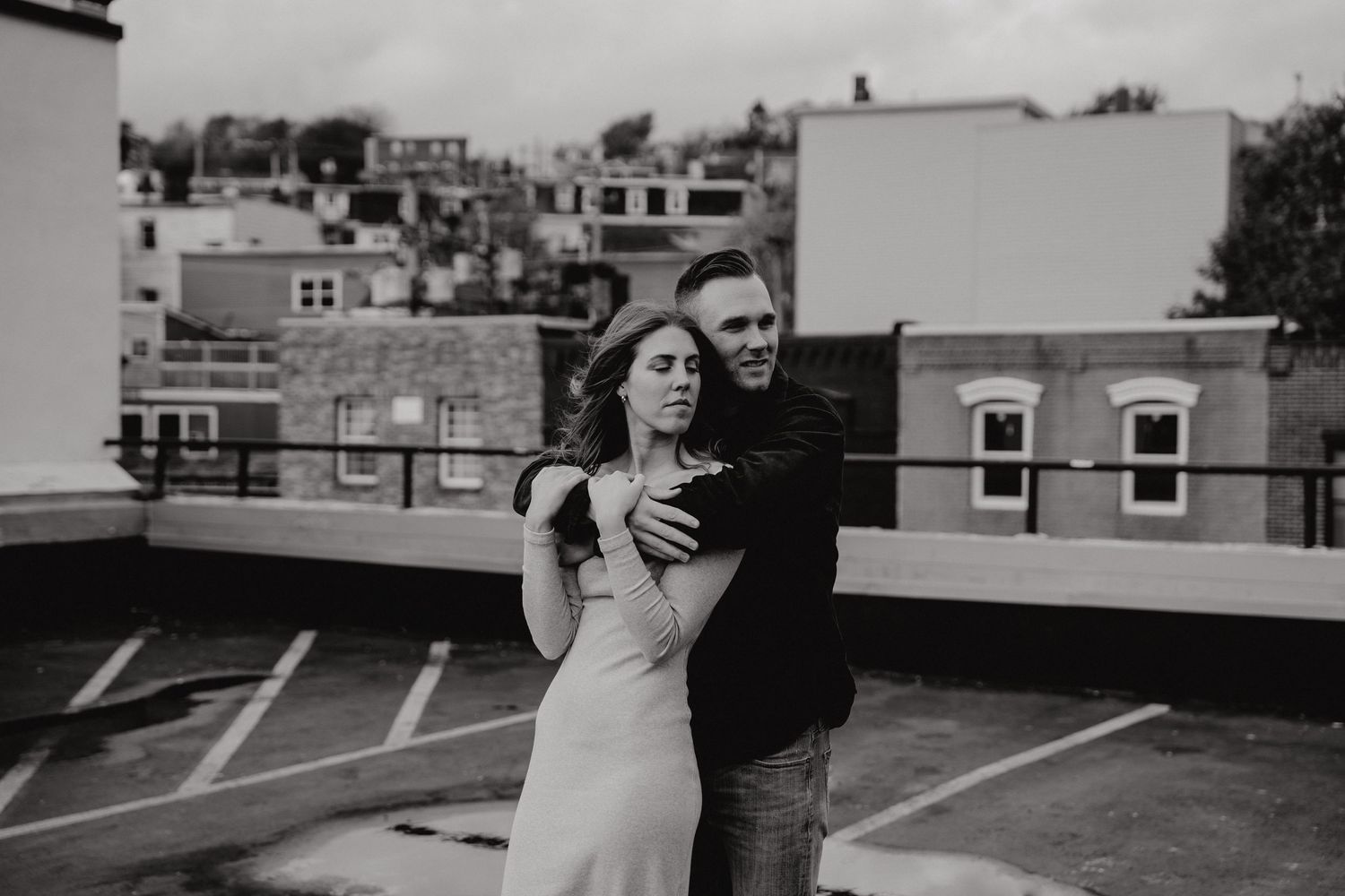 Urban rooftop photoshoot featuring a couple in casual wear against city buildings.