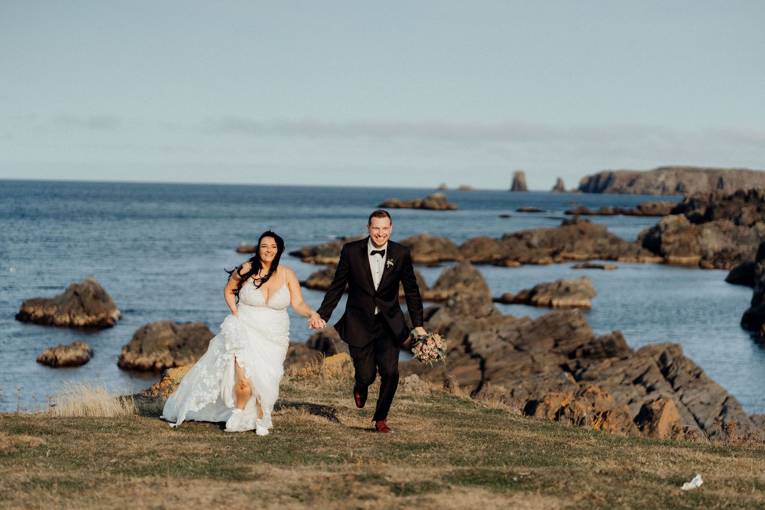 Wedding photo session along rocky coastal cliffs with ocean views.