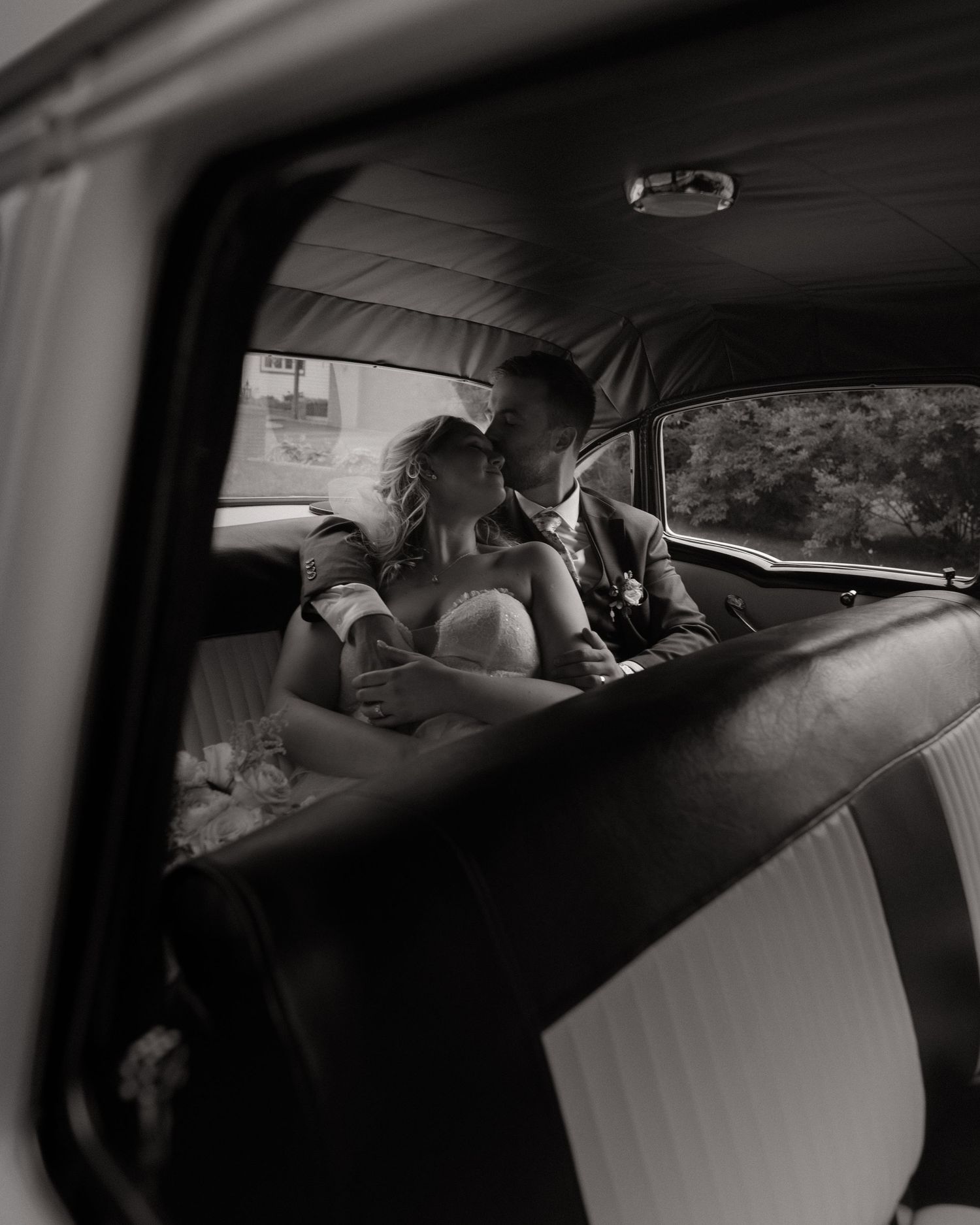 Black and white photo sequence showing someone reaching and moving around in a car interior.