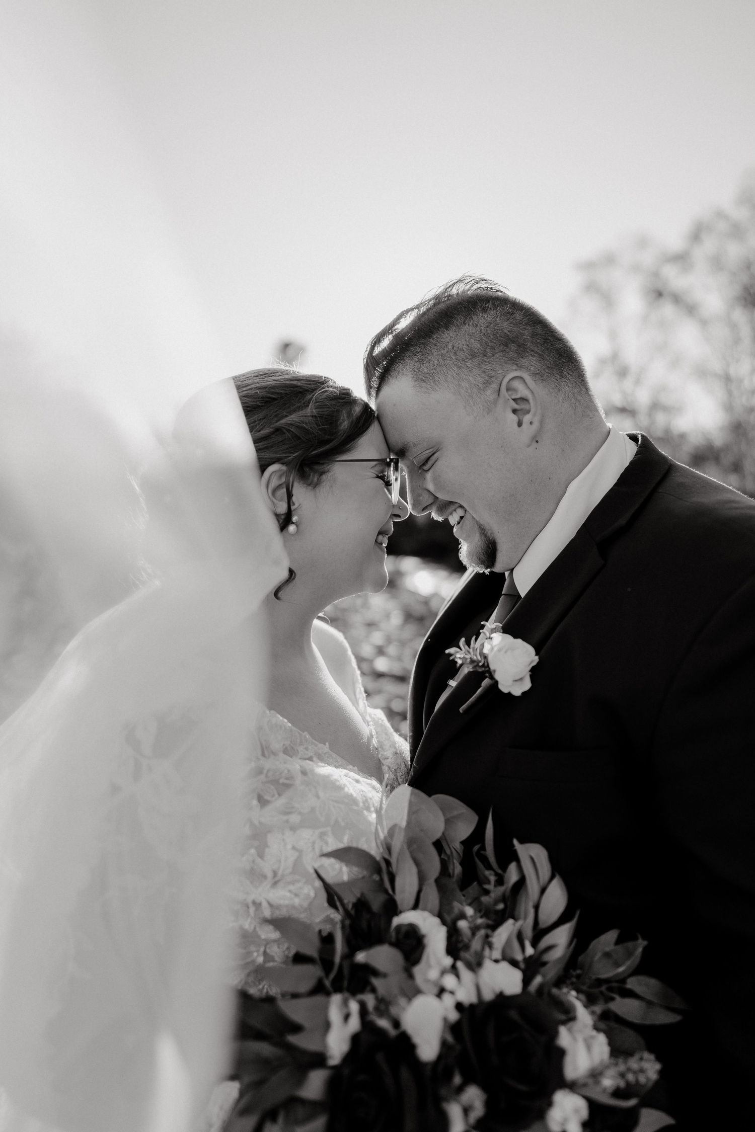 Black and white intimate wedding moment captured with delicate floral details.