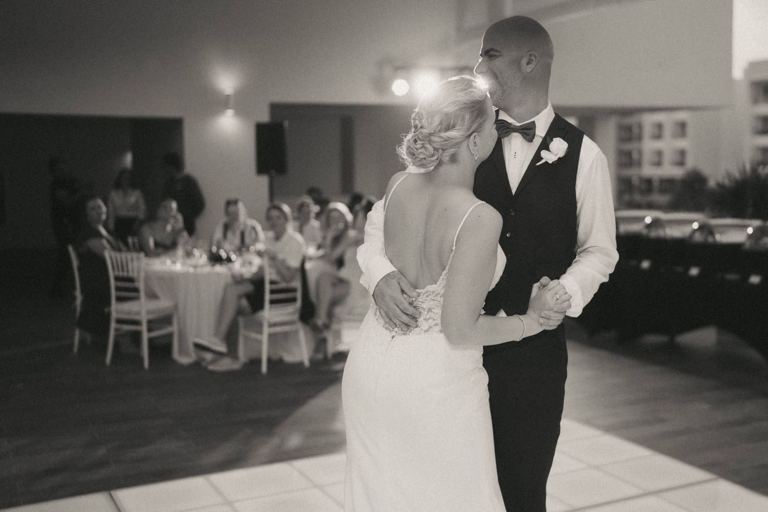 Black and white reception photos capturing intimate dance moments on a glowing dance floor.