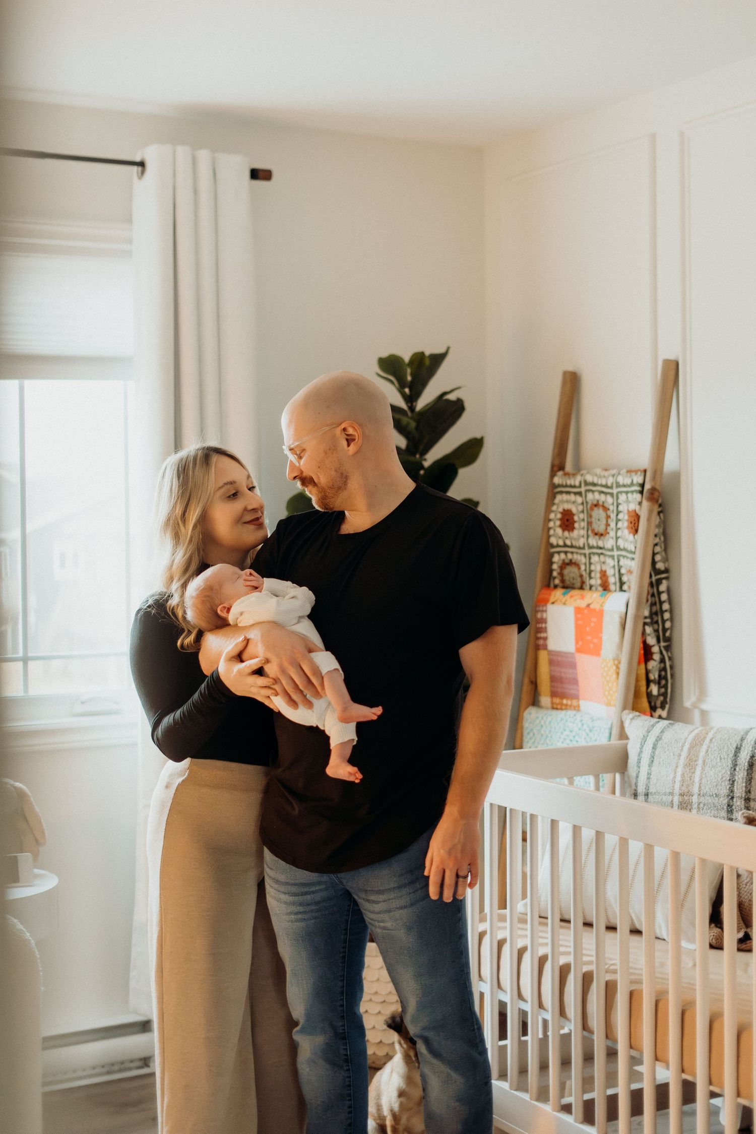 Candid family interaction captured in sequence in front of white crib.