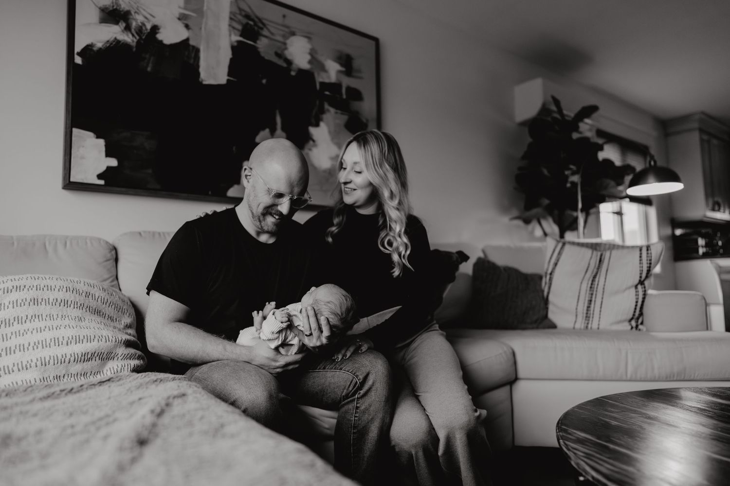 Black and white panoramic shot of family lifestyle session in living room setting.