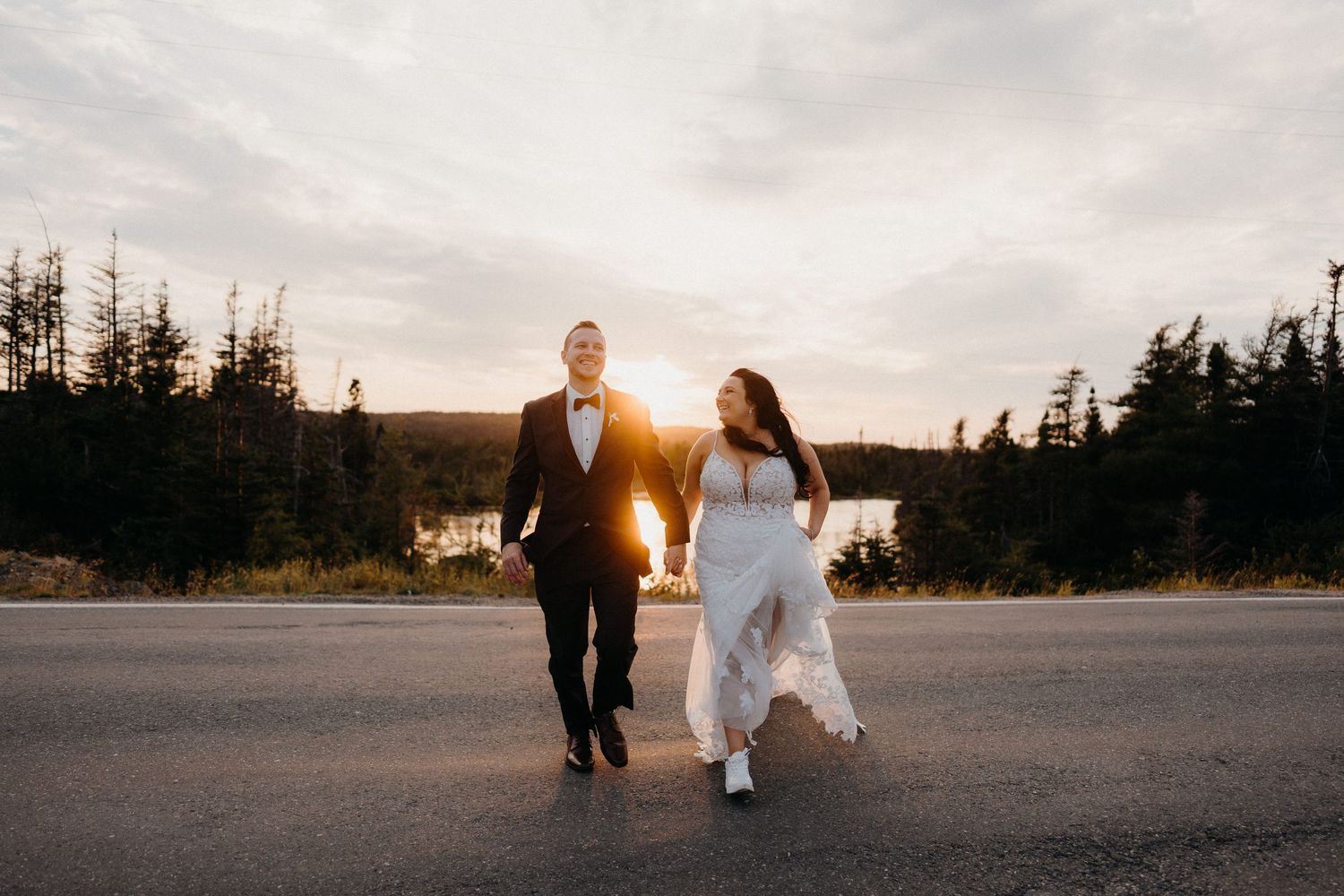 Couple strolling through mountain landscape at sunset with dramatic lighting.
