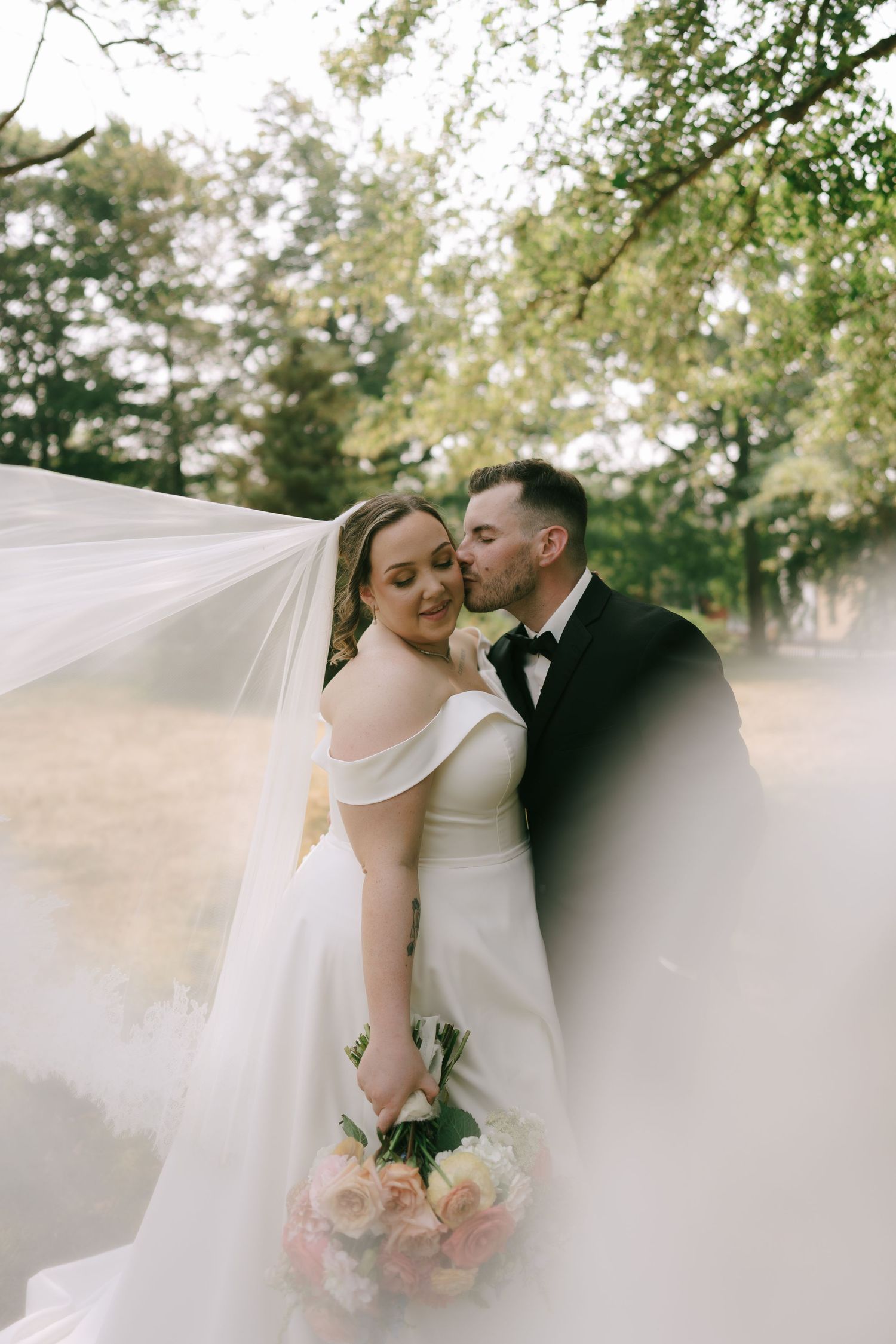 Artistic wedding photo series with flowing veil and soft natural lighting in an outdoor garden setting.
