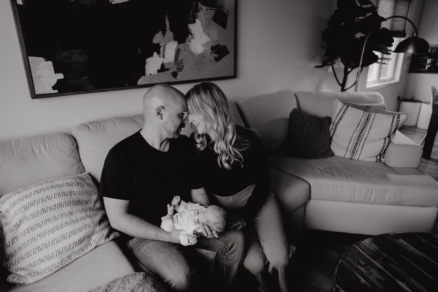Tender lifestyle photo session on a couch with soft natural light showing intimate family moments.