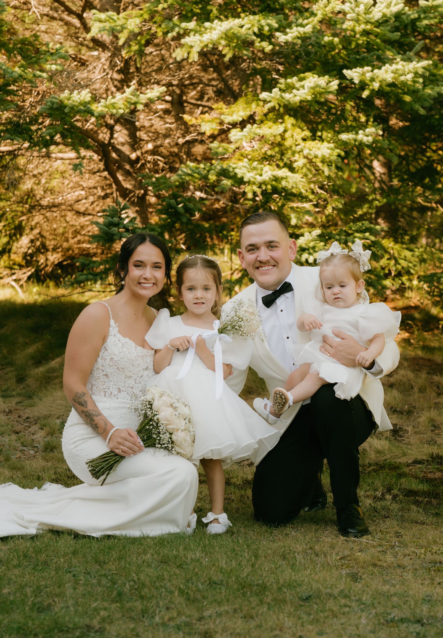 Elegant wedding portrait taken outdoors in autumn with white formal attire and natural foliage backdrop.