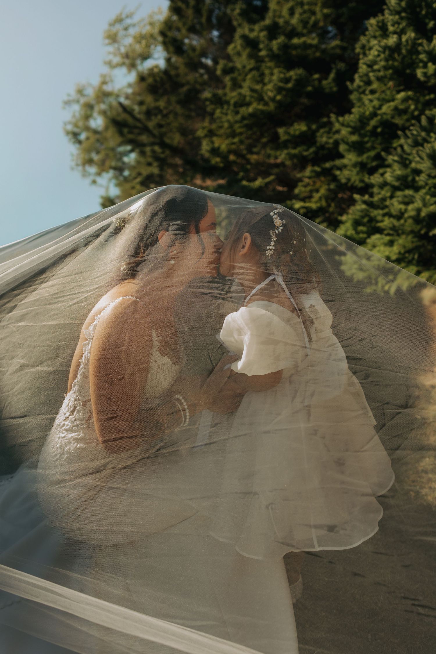 A series of photos showing a person behind a translucent veil or fabric in natural outdoor lighting.