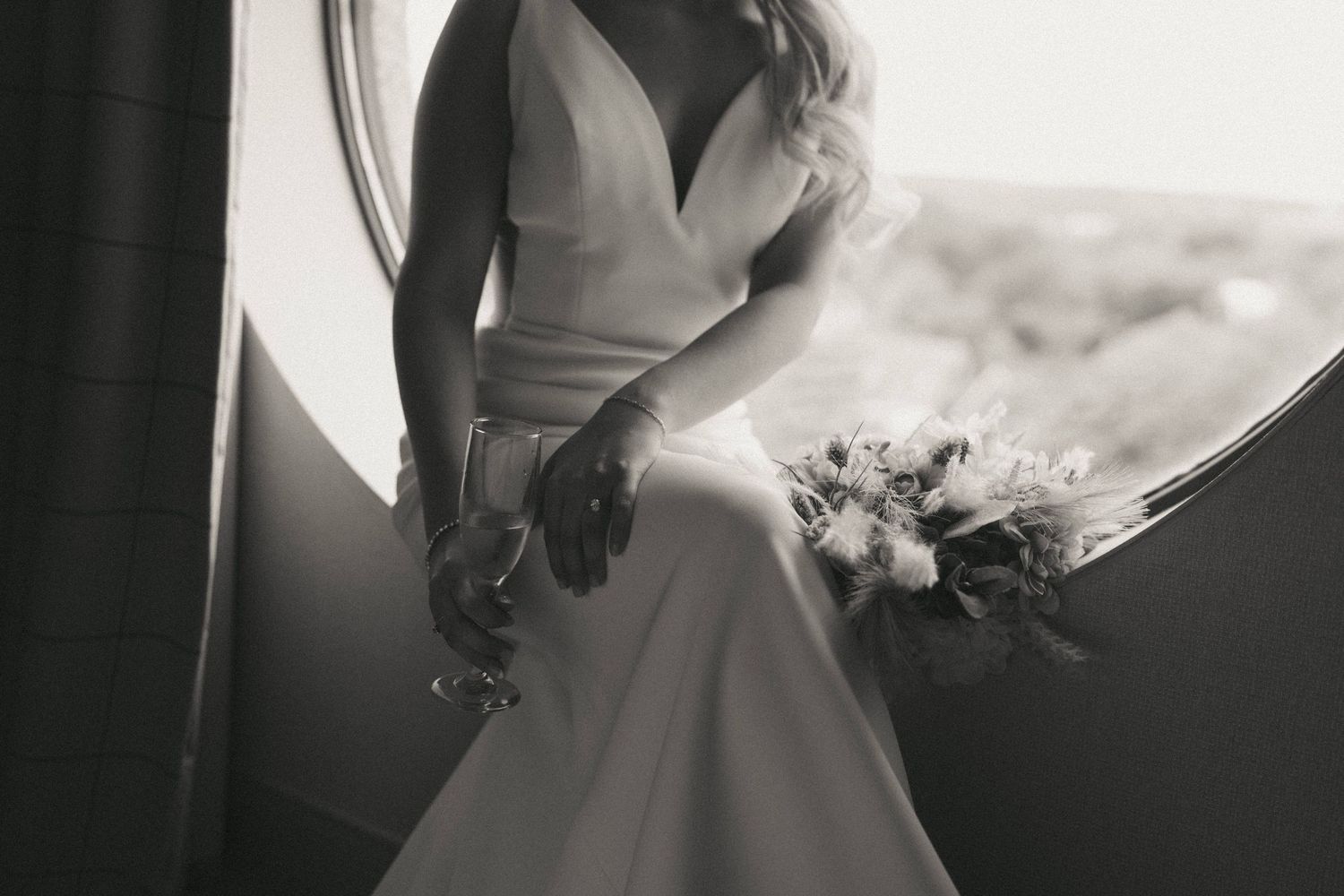 Elegant details of a white wedding dress captured in dramatic black and white photography.