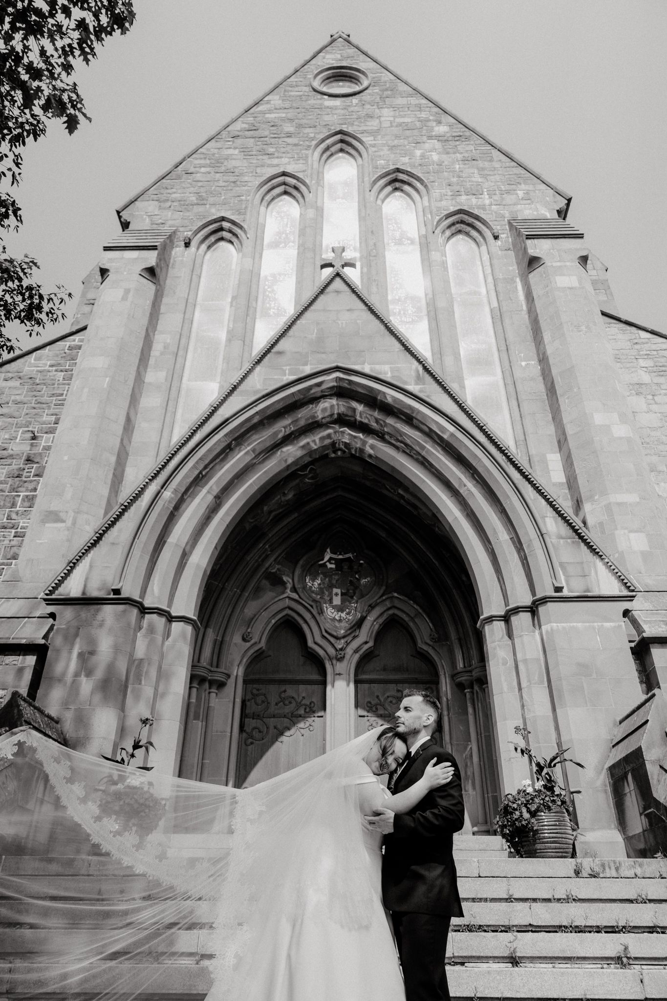 A beautiful Gothic church facade with arched windows and doorway photographed in black and white.
