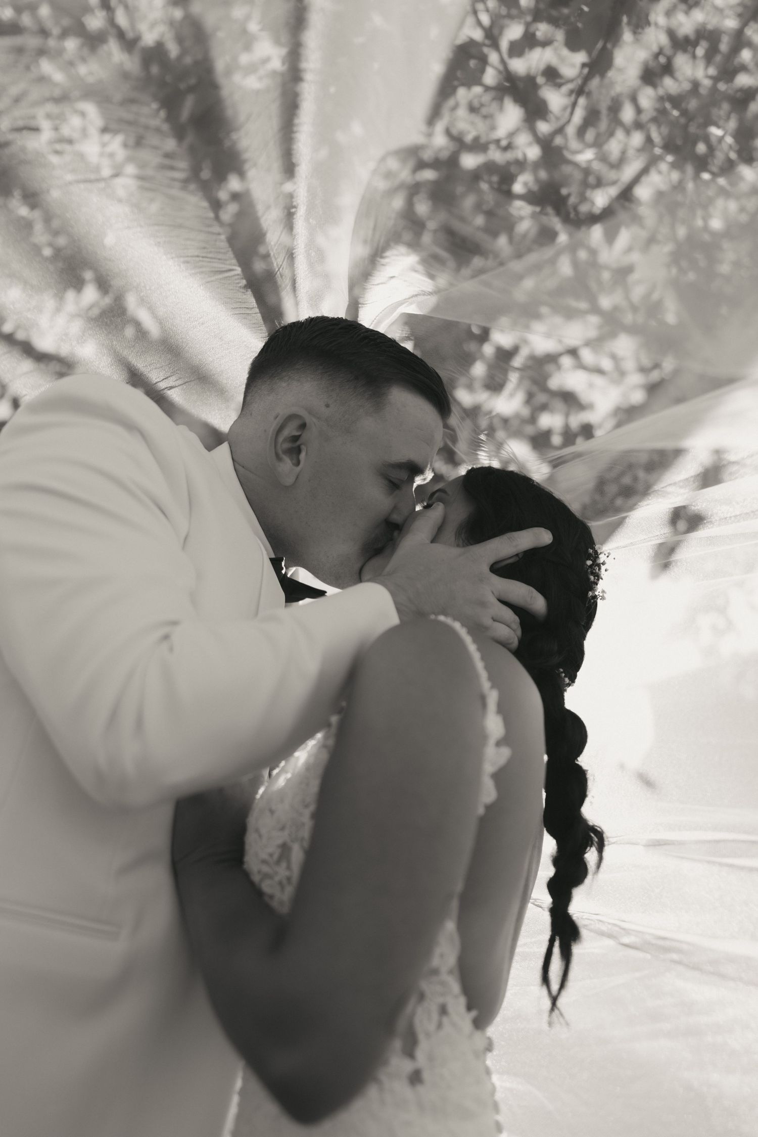 A romantic sequence of black and white photos showing a couple sharing a tender kiss during their wedding celebration.