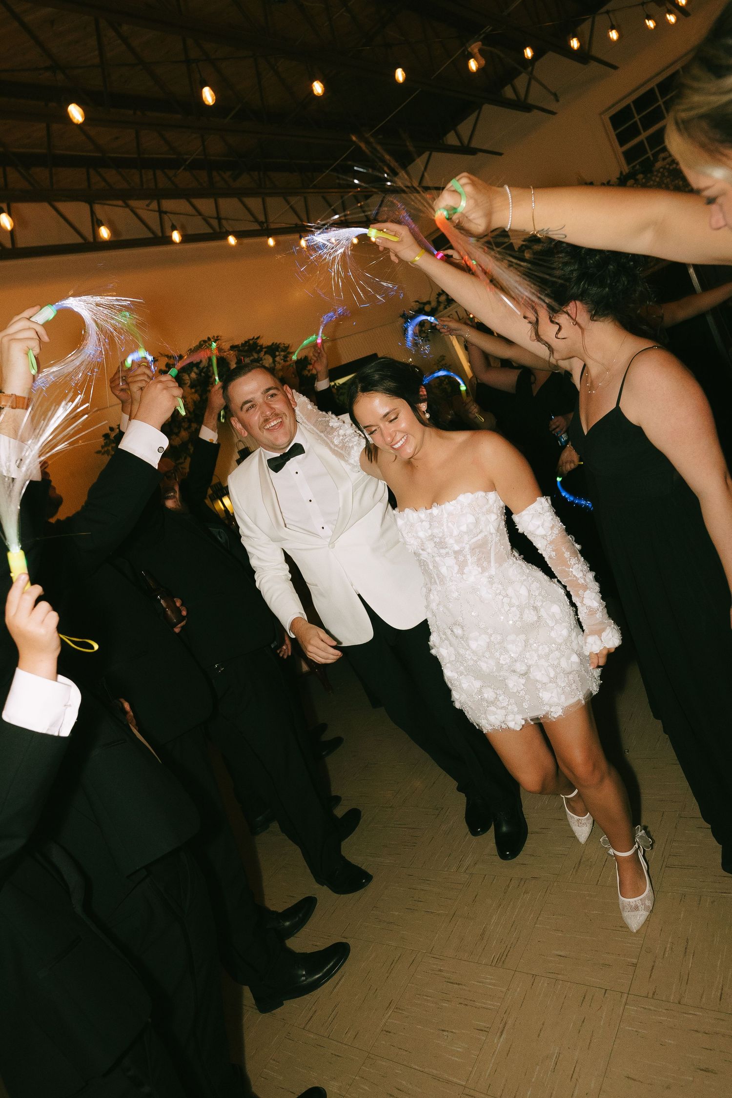 A series of wedding reception photos showing guests dancing and forming a limbo line under string lights.